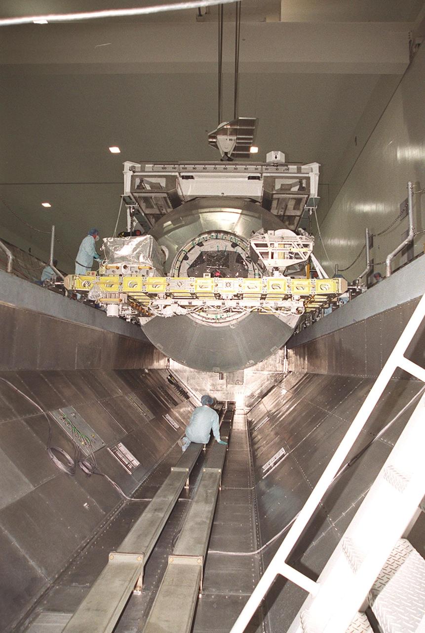 The Multi-Purpose Logistics Module Leonardo is placed inside the payload canister while workers below and on the side check its progress. The MPLM is being transferred to Launch Pad 39B for installation in Space Shuttle Discovery. Leonardo, one of Italy’s major contributions to the International Space Station program, is a reusable logistics carrier. It is the primary delivery system used to resupply and return Station cargo requiring a pressurized environment. Leonardo is the primary payload on mission STS-102 and will deliver up to 10 tons of laboratory racks filled with equipment, experiments and supplies for outfitting the newly installed U.S. Laboratory Destiny. STS-102 is scheduled to launch March 8 at 6:45 a.m. EST