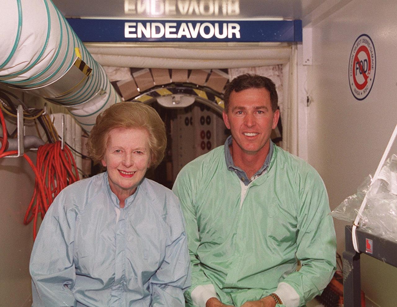 At the entrance to orbiter Endeavour, Lady Margaret Thatcher (left), former Prime Minister of Britain, poses with United Space Alliance technician Mike Parrish (right) who was her guide through the vehicle. The orbiter, which is in the Orbiter Processing Facility bay 2, is flying on mission STS-100, the ninth construction flight to the International Space Station