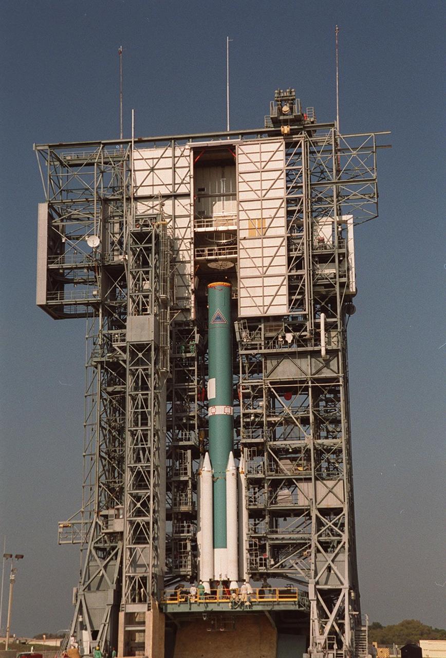 The moveable gantry closes in on a Delta 7925 rocket, bringing an additional three solid rocket boosters for mating to the rocket. Scheduled to launch April 7, 2001, the rocket will carry the 2001 Mars Odyssey Orbiter, containing three science instruments: THEMIS, the Gamma Ray Spectrometer (GRS), and the Mars Radiation Environment Experiment (MARIE). THEMIS will map the mineralogy and morphology of the Martian surface using a high-resolution camera and a thermal infrared imaging spectrometer. The GRS will achieve global mapping of the elemental composition of the surface and determine the abundance of hydrogen in the shallow subsurface. The MARIE will characterize aspects of the near-space radiation environment with regards to the radiation-related risk to human explorers