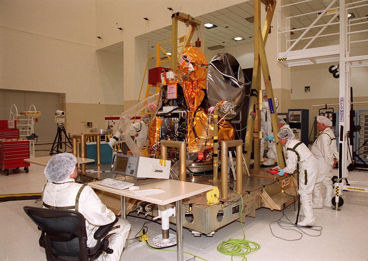 Workers in the Spacecraft Assembly and Encapsulation Facility (SAEF 2) get ready to conduct an illumination test on the 2001 Mars Odyssey Orbiter. Various components of the Odyssey Orbiter are undergoing testing. Scheduled for launch April 7, 2001, the orbiter contains three science instruments: THEMIS, the Gamma Ray Spectrometer (GRS), and the Mars Radiation Environment Experiment (MARIE). THEMIS will map the mineralogy and morphology of the Martian surface using a high-resolution camera and a thermal infrared imaging spectrometer. The GRS will achieve global mapping of the elemental composition of the surface and determine the abundance of hydrogen in the shallow subsurface. The MARIE will characterize aspects of the near-space radiation environment with regards to the radiation-related risk to human explorers