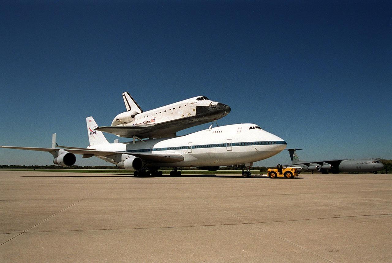 The Shuttle Carrier Aircraft, with its piggyback cargo the orbiter Atlantis, is towed to the parking area at the Shuttle Landing Facility. There it will be demated from the orbiter in the mate/demate device. Atlantis landed in California Feb. 19 concluding mission STS-98. The ferry flight began in California March 1; unfavorable weather conditions kept it on the ground at Altus AFB, Okla., until it could return to Florida. The orbiter will next fly on mission STS-104, the 10th construction flight to the International Space Station, scheduled June 8