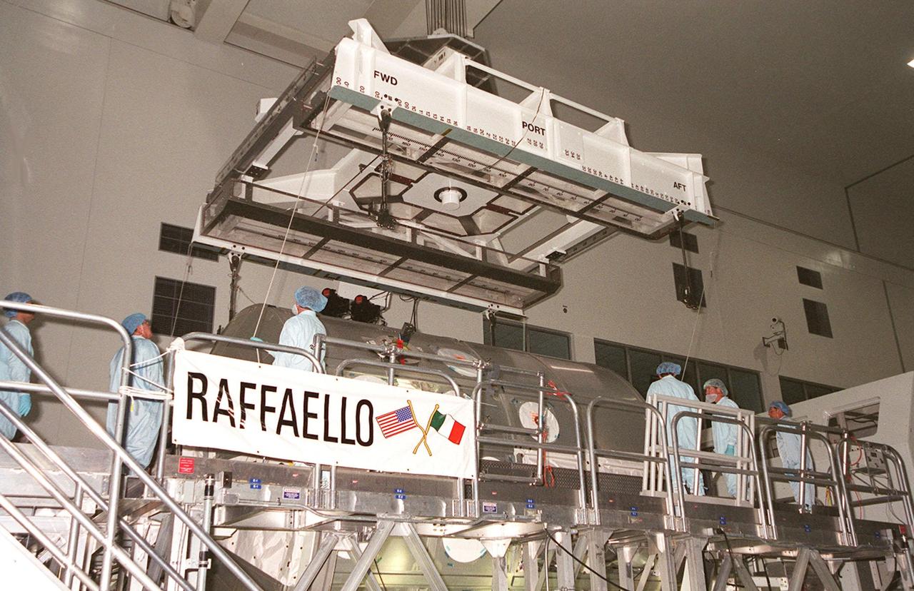 In the Space Station Processing Facility, an overhead crane is lowered toward the Multi-Purpose Logistics Module Raffaello so workers can attach it. The MPLM will be lifted and moved to a scale for weight and balance. Raffaello is the second MPLM built by the Italian Space Agency, and serves as a reusable logistics carrier and primary delivery system used to resupply and return station cargo requiring a pressurized environment. Weighing nearly 4.5 tons, the Raffaello measures 21 feet long and 15 feet in diameter. The MPLM will fly on mission STS-100, scheduled to launch aboard Space Shuttle Endeavour on April 19