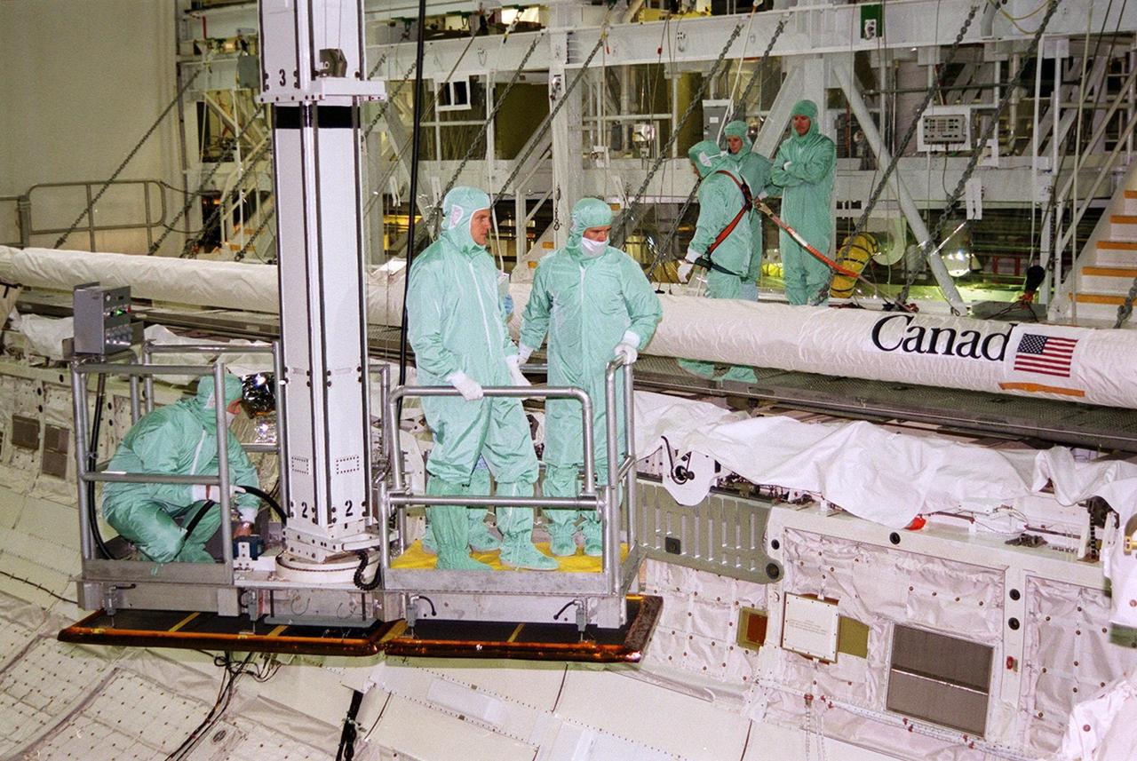 In the Orbiter Processing Facility bay 2, members of the STS-100 crew get a look at the payload inside Endeavour. Stretching the length of the payload bay is the Canadian robotic arm, SSRMS, that they will be attaching to the Space Station for use in assembling future components. . The crew, who are taking part in a Crew Equipment Interface Test (CEIT), comprises Commander Kent V. Rominger, Pilot Jeffrey S. Ashby and Mission Specialists Chris Hadfield, who is with the Canadian Space Agency, Scott Parazynski, John L. Phillips, Umberto Guidoni, who is with the European Space Agency, and Yuri Lonchakov, who is with the Russian Aviation and Space Agency. Endeavour is also carrying the Multi-Purpose Logistics Module Raffaello to the International Space Station. Raffaello carries six system racks and two storage racks for the U.S. Lab. Launch of mission STS-100 is scheduled for April 19 at 2:41 p.m. EDT from Launch Pad 39A