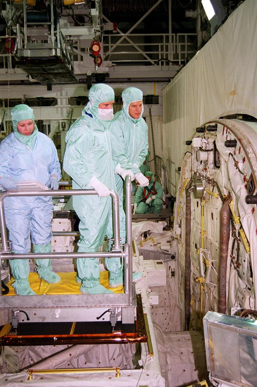 STS-100 Mission Specialists Scott Parazynski and Chris Hadfield look at the reel tether on the crew compartment hatch. They are taking part in a Crew Equipment Interface Test (CEIT) along with other crew members Commander Kent V. Rominger, Pilot Jeffrey S. Ashby and Mission Specialists John L. Phillips, Umberto Guidoni, who is with the European Space Agency, and Yuri Lonchakov, who is with the Russian Aviation and Space Agency. Endeavour is also carrying the Multi-Purpose Logistics Module Raffaello to the International Space Station. Raffaello carries six system racks and two storage racks for the U.S. Lab. Launch of mission STS-100 is scheduled for April 19 at 2:41 p.m. EDT from Launch Pad 39A