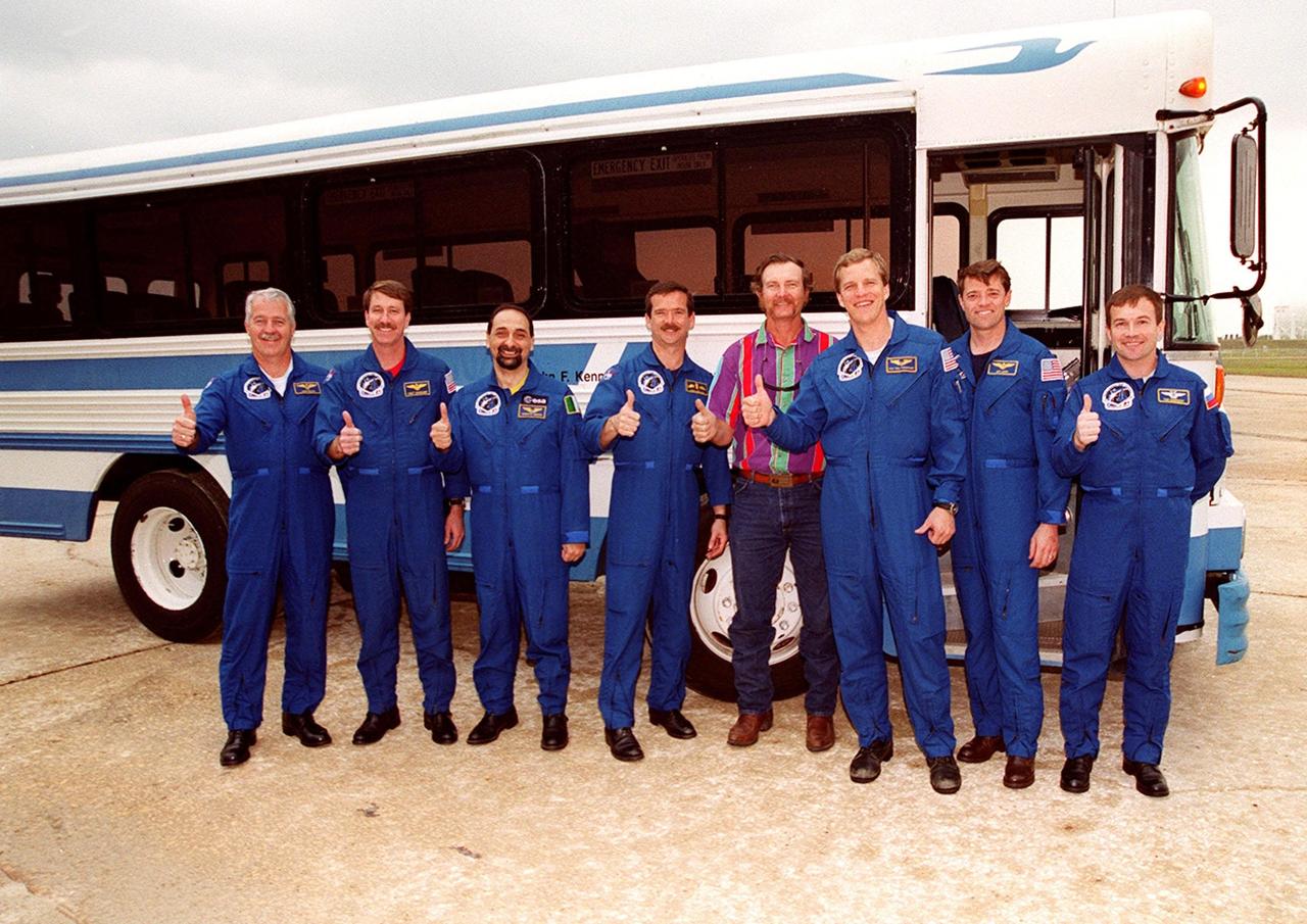 The STS-100 crew gathers at the bus when Terminal Countdown Demonstration Test activities are hampered by the rain. Standing with the bus driver, from left, are Mission Specialist John L. Phillips, Commander Kent V. Rominger, Mission Specialists Umberto Guidoni, Chris Hadfield, [driver], and Scott E. Parazynski, Pilot Jeffrey S. Ashby and Mission Specialist Yuri V. Lonchakov. TCDT includes emergency escape training at the pad and a simulated launch countdown. The mission is carrying the Multi-Purpose Logistics Module Raffaello and the Canadian robotic arm, SSRMS, to the International Space Station. Raffaello carries six system racks and two storage racks for the U.S. Lab. The SSRMS is crucial to the continued assembly of the orbiting complex. Launch of mission STS-100 is scheduled for April 19 at 2:41 p.m. EDT from Launch Pad 39A