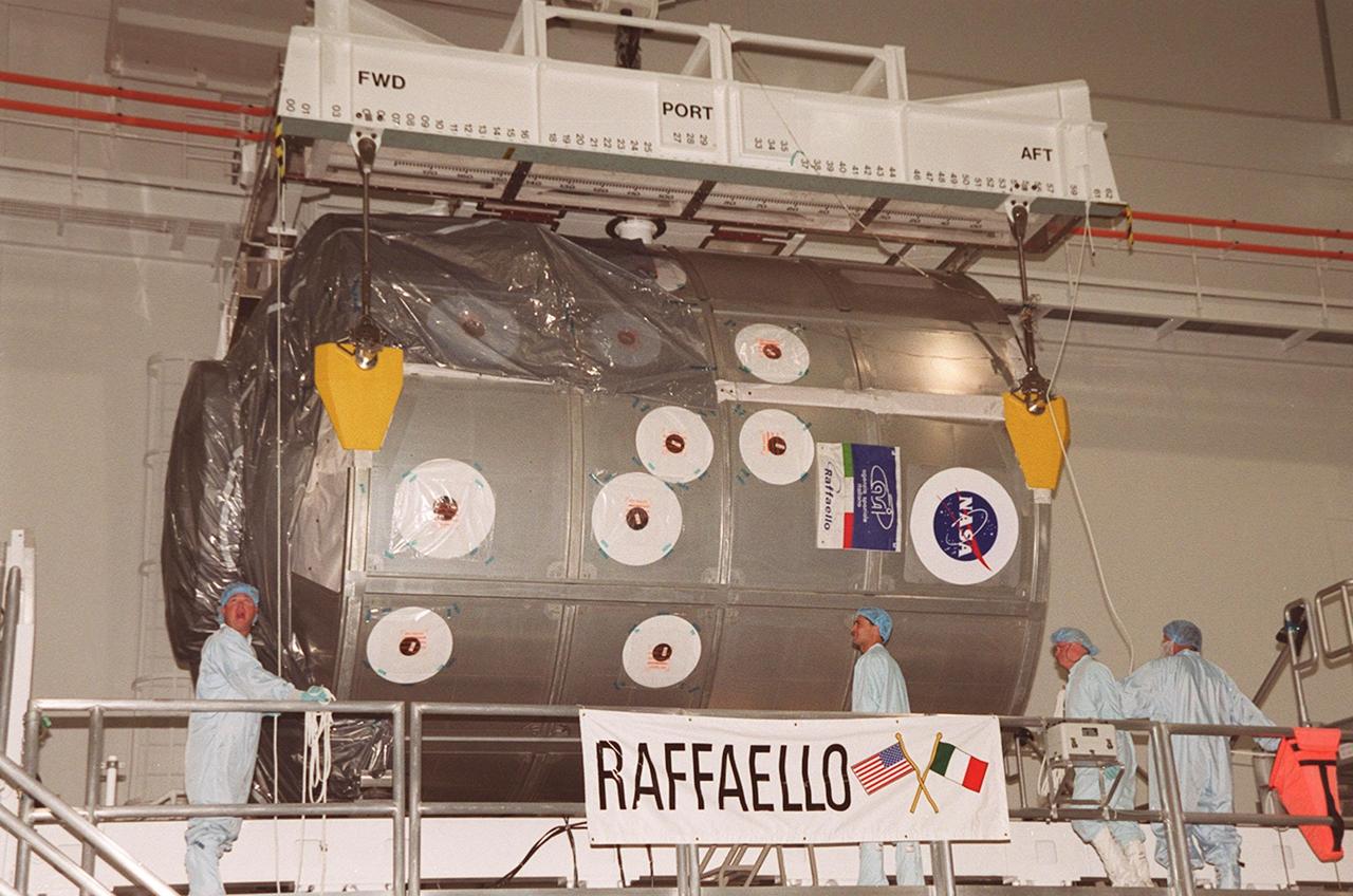 In the Space Station Processing Facility, an overhead crane is ready to lift the Multi-Purpose Logistics Module Raffaello in order to move it to the payload canister. Part of the payload on mission STS-100 to the International Space Station, Raffaello carries six system racks and two storage racks for the U.S. Lab. Launch of STS-100 is scheduled for April 19, 2001 at 2:41 p.m. EDT from Launch Pad 39A