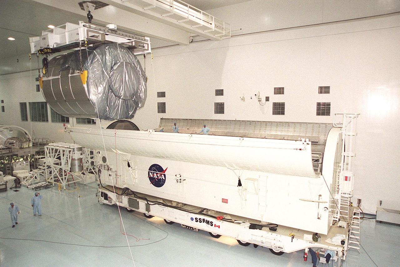 Suspended by the overhead crane, the Multi-Purpose Logistics Module Raffaello approaches the end of the payload canister. Part of the payload on mission STS-100 to the International Space Station, Raffaello carries six system racks and two storage racks for the U.S. Lab. Launch of STS-100 is scheduled for April 19, 2001 at 2:41 p.m. EDT from Launch Pad 39A