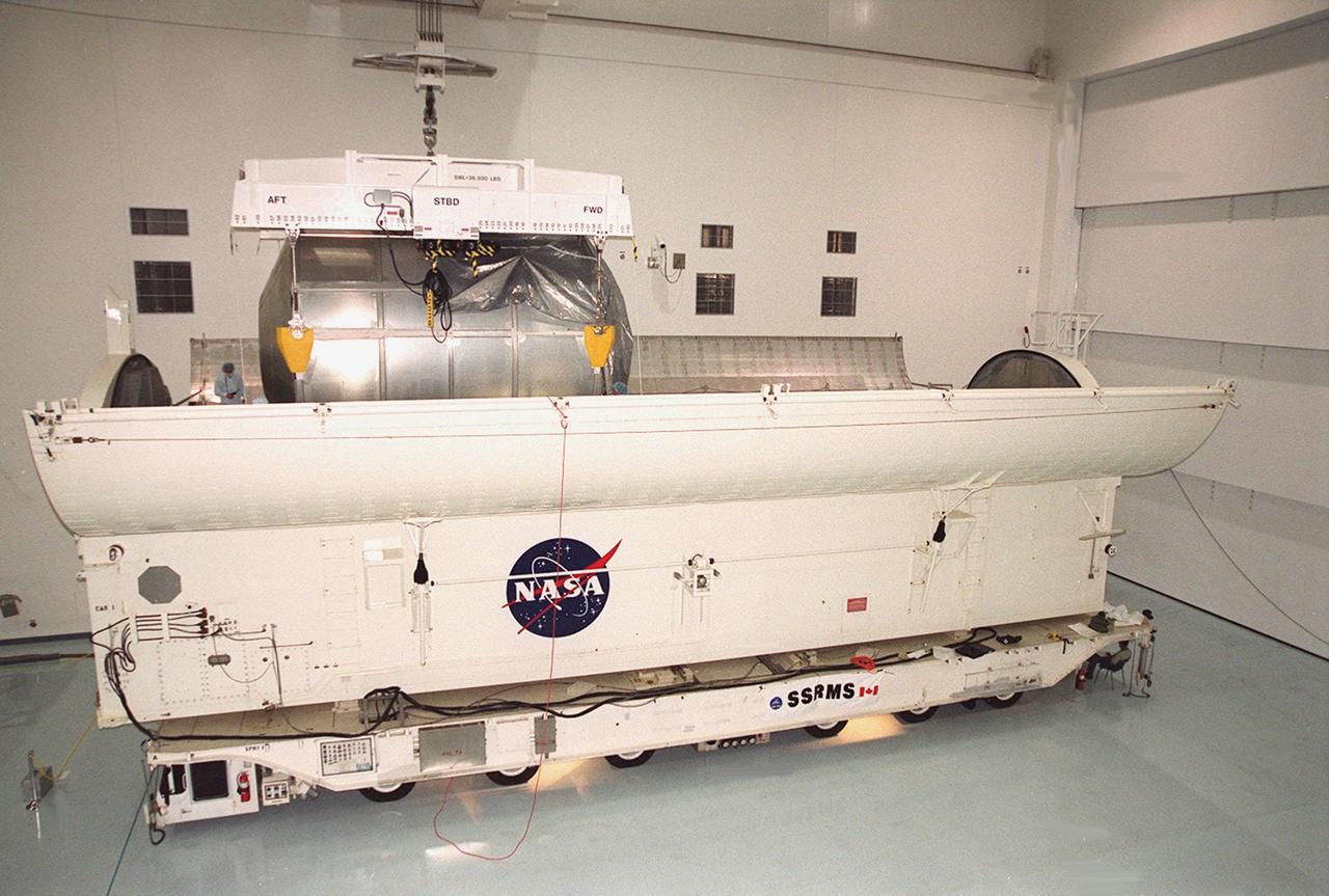 The Multi-Purpose Logistics Module Raffaello is lowered into the payload canister alongside the Canadian robotic arm, SSRMS, already in place. Both elements are part of the payload on mission STS-100 to the International Space Station. Raffaello carries six system racks and two storage racks for the U.S. Lab. The arm has seven motorized joints and is capable of handling large payloads and assisting with docking the Space Shuttle. The SSRMS is self-relocatable with a Latching End Effector so it can be attached to complementary ports spread throughout the Station’s exterior surfaces. Launch of STS-100 is scheduled for April 19, 2001 at 2:41 p.m. EDT from Launch Pad 39A