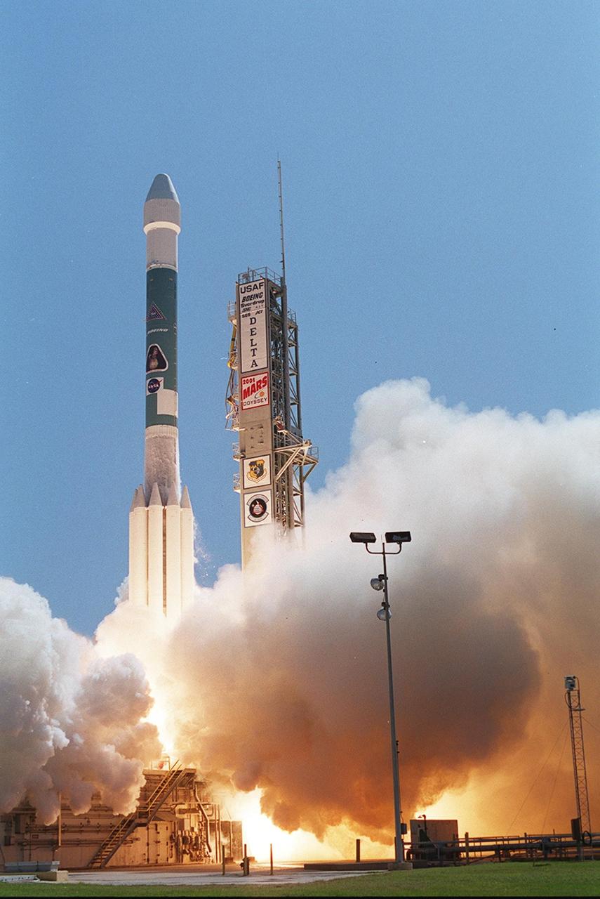 Smoke clouds pour across the ground as the Boeing Delta II rocket carrying the 2001 Mars Odyssey spacecraft leaps into the clear blue sky. Liftoff occurred at 11:02 a.m. EDT. The launch sends the Mars Odyssey on an approximate 7-month journey to orbit the planet Mars. The spacecraft, built by Lockheed Martin Space Systems for the Jet Propulsion Laboratory, will map the Martian surface looking for geological features that could indicate the presence of water, now or in the past. Science gathered by three science instruments on board will be key to future missions to Mars, including orbital reconnaissance, lander and human missions