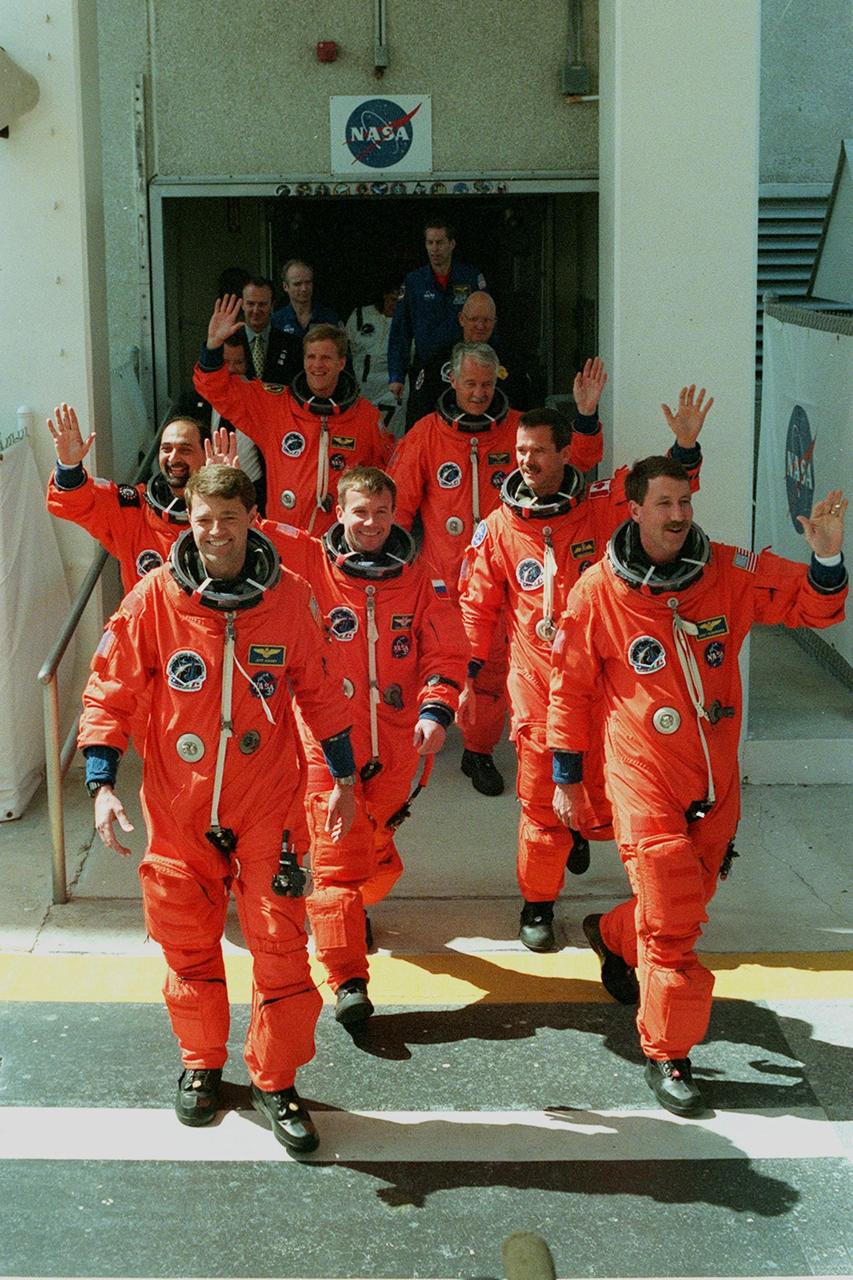The STS-100 crew walks out of the Operations and Checkout Building on their way to Launch Pad 39A and liftoff for an 11-day mission to the International Space Station. Leading in front are Pilot Jeffrey S. Ashby (left) and Commander Kent V. Rominger (right). Behind them are (left to right) Mission Specialists Umberto Guidoni, Yuri Lonchakov and Chris A. Hadfield. Following in the rear are Mission Specialists Scott E. Parazynski (left) and John L. Phillips (right). An international crew, Guidoni represents the European Space Agency, Lonchakov the Russian Aviation and Space Agency and Hadfield the Canadian Space Agency. Space Shuttle Endeavour and its crew will deliver and integrate the Spacelab Logistics Pallet/Launch Deployment Assembly, which includes the Space Station Remote Manipulator System and the UHF Antenna. The mission includes two planned spacewalks for installation of the SSRMS, which will be performed by Parazynski and Hadfield. The mission is also the inaugural flight of Multi-Purpose Logistics Module Raffaello, carrying resupply stowage racks and resupply/return stowage platforms. Liftoff of Space Shuttle Endeavour on mission STS-100 is scheduled at 2:41 p.m. EDT April 19