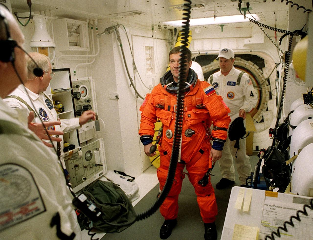 In the White Room, STS-100 Mission Specialist Yuri V. Lonchakov (center) is checked by closeout crew members (from left) Greg Johnson, Danny Wyatt and Rene Arriens before entering Space Shuttle Endeavour. The White Room is an environmental chamber at the end of the Orbiter Access Arm that provides entry into the orbiter on the launch pad. The mission will deliver and integrate the Spacelab Logistics Pallet/Launch Deployment Assembly, which includes the Canadian-built Space Station Remote Manipulator System and the UHF Antenna. Two spacewalks are planned for installation of the SSRMS, which will be performed by Mission Specialists Scott E. Parazynski and Chris A. Hadfield, who is with the Canadian Space Agency. The mission is also the inaugural flight of Multi-Purpose Logistics Module Raffaello, carrying resupply stowage racks and resupply/return stowage platforms. Liftoff of Space Shuttle Endeavour on mission STS-100 is scheduled at 2:41 p.m. EDT April 19