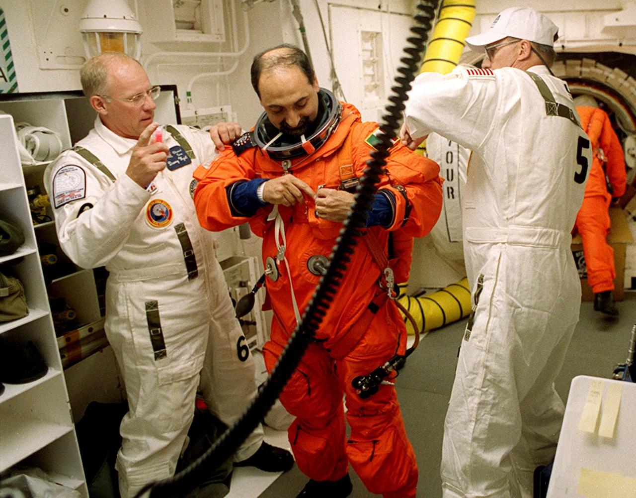 In the White Room, STS-100 Mission Specialist Umberto Guidoni is helped with his launch and entry suit by closeout crew members Danny Wyatt (left) and George Schramm (right). Guidoni is with the European Space Agency. The White Room is an environmental chamber at the end of the Orbiter Access Arm that provides entry into the orbiter on the launch pad. The mission will deliver and integrate the Spacelab Logistics Pallet/Launch Deployment Assembly, which includes the Canadian-built Space Station Remote Manipulator System and the UHF Antenna. Two spacewalks are planned for installation of the SSRMS, which will be performed by Mission Specialists Scott E. Parazynski and Chris A. Hadfield, who is with the Canadian Space Agency. The mission is also the inaugural flight of the Multi-Purpose Logistics Module Raffaello, carrying resupply stowage racks and resupply/return stowage platforms. Liftoff of Space Shuttle Endeavour on mission STS-100 is scheduled at 2:41 p.m. EDT April 19