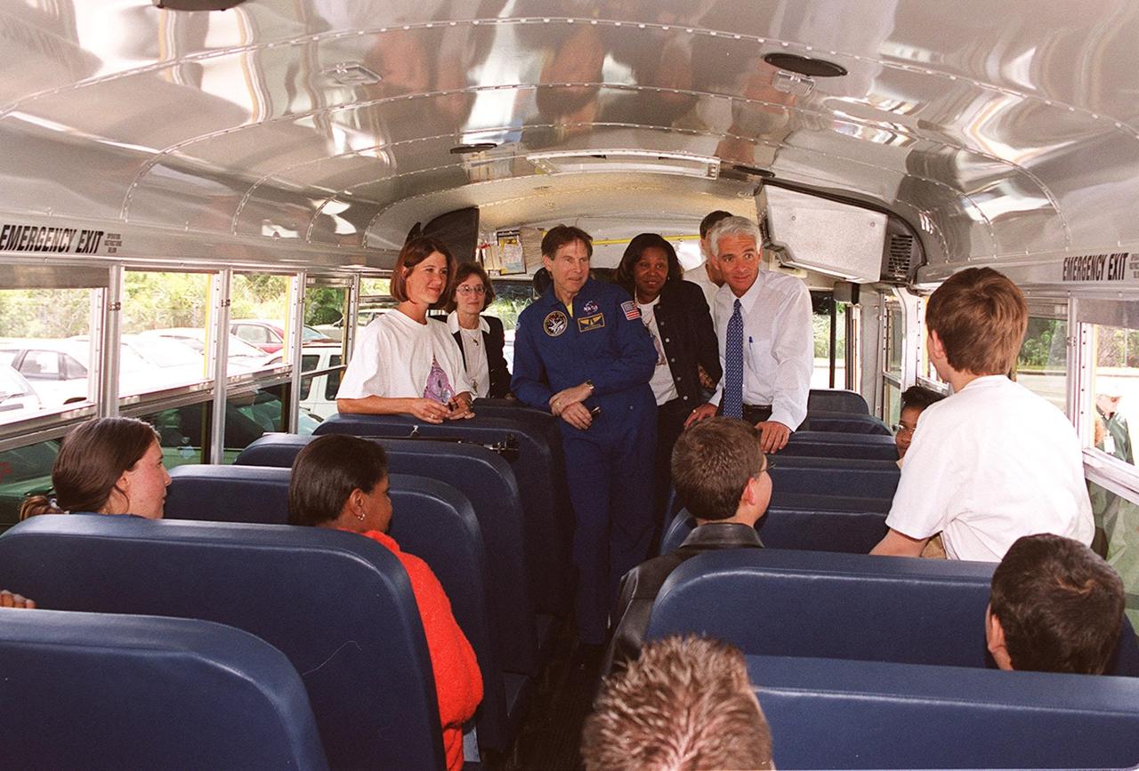 KENNEDY SPACE CENTER, FLA. -- State Education Commissioner Charlie Crist (background, right) talks to students from Ronald McNair Magnet School, Cocoa, Fla., on the school bus that brought them to KSC for the launch of Space Shuttle Endeavour on mission STS-100. Crist was commemorating the 20th anniversary of Space Shuttle program with his visit to KSC for the launch. In uniform (center) is astronaut Sam Durrance, who also accompanied the students. At far left is teacher Nicole Waxberg, who chaperoned the students