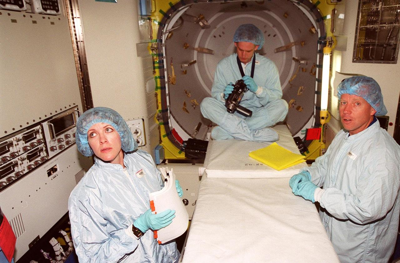 KENNEDY SPACE CENTER, FLA. -- Members of the STS-104 crew look over equipment inside the equipment lock component of the Joint Airlock Module. At left is Mission Specialist Janet L. Kavandi, and at right Pilot Charles O. Hobaugh. The crew is at KSC to take part in Crew Equipment Interface Test activities. The mission will carry the Joint Airlock Module to the International Space Station. The U.S.-made module will allow astronauts and cosmonauts in residence on the Station to perform future spacewalks without the presence of a Space Shuttle. The module, which also comprises a crew lock, will be connected to the starboard (right) side of Node 1 Unity. Atlantis will also carry oxygen and nitrogen storage tanks, vital to operation of the Joint Airlock, on a Spacelab Logistics Double Pallet in the payload bay. The tanks, to be installed on the perimeter of the Joint Module during the mission’s spacewalks, will support future spacewalk operations and experiments plus augment the resupply system for the Station’s Service Module