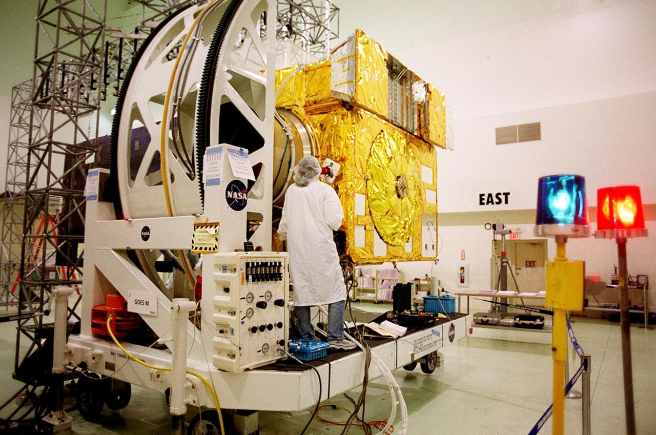 At Astrotech, Titusville, Fla., a worker checks components of the GOES-M satellite. The GOES-M provides weather imagery and quantitative sounding data used to support weather forecasting, severe storm tracking and meteorological research. The satellite is scheduled to launch July 12 on an Atlas-IIA booster, Centaur upper stage from Cape Canaveral Air Force Station