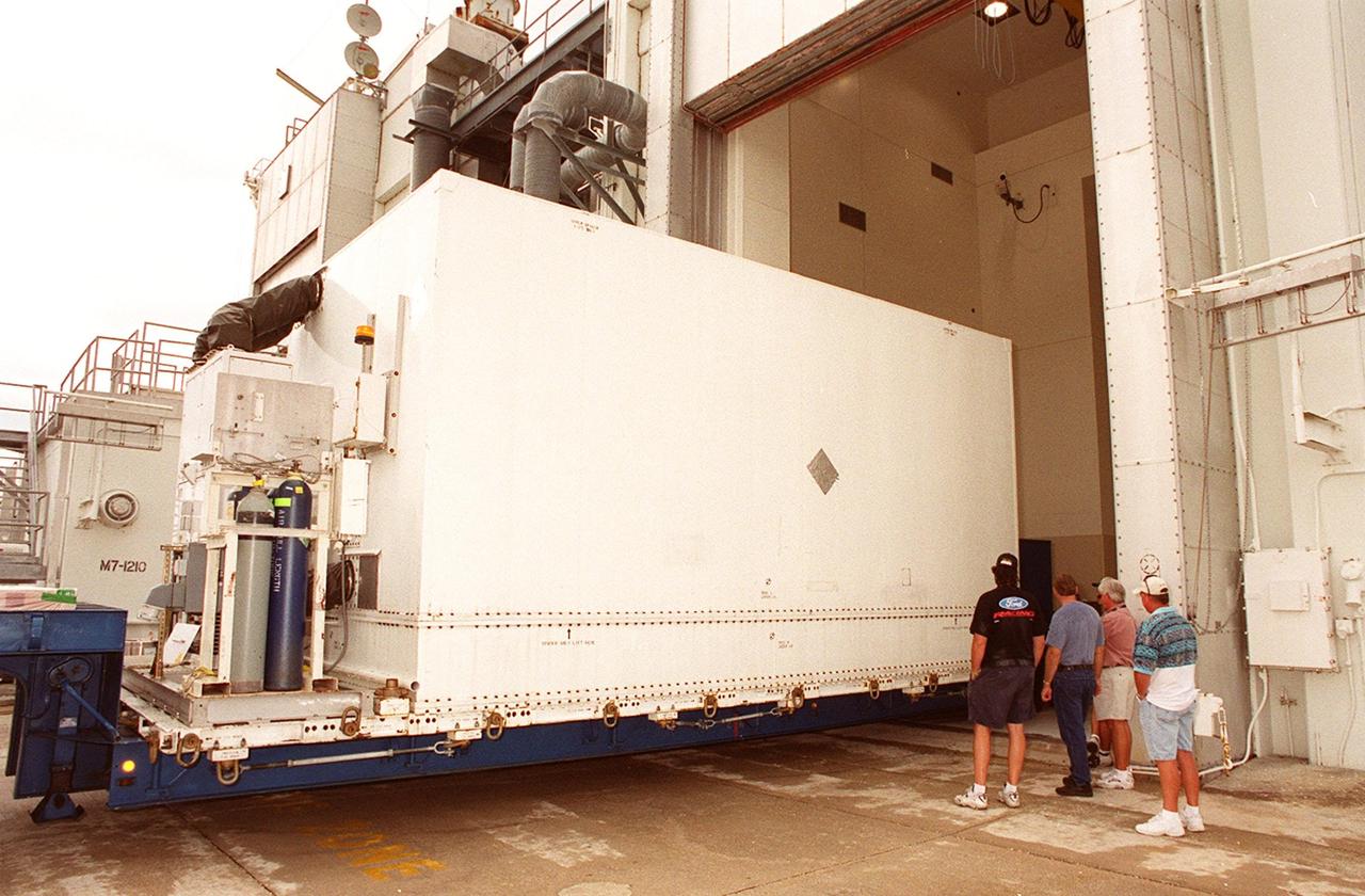 KENNEDY SPACE CENTER, FLA. -- The container with the Microwave Anisotropy Probe (MAP) satellite inside is backed into the Spacecraft Assembly and Encapsulation Facility 2. MAP will undergo testing in the SAEF-2 before its scheduled launch June 30 from Cape Canaveral Air Force Station on a Delta II rocket into a lunar-assisted trajectory to the Sun-Earth for a 27-month mission (3 months transit, 24 months observing). The MAP instrument consists of a set of passively cooled microwave radiometers with 1.4x 1.6-meter diameter primary reflectors to provide the desired angular resolution. MAP measures small fluctuations in the temperature of the cosmic microwave background radiation to an accuracy of one millionth of a degree. These measurements should reveal the size, matter content, age, geometry and fate of the universe. They will also reveal the primordial structure that grew to form galaxies and will test ideas about the origins of these primordial structures. The MAP instrument will be continuously shaded from the Sun, Earth, and Moon by the spacecraft. It is a product of Goddard Space Flight Center in partnership with Princeton University