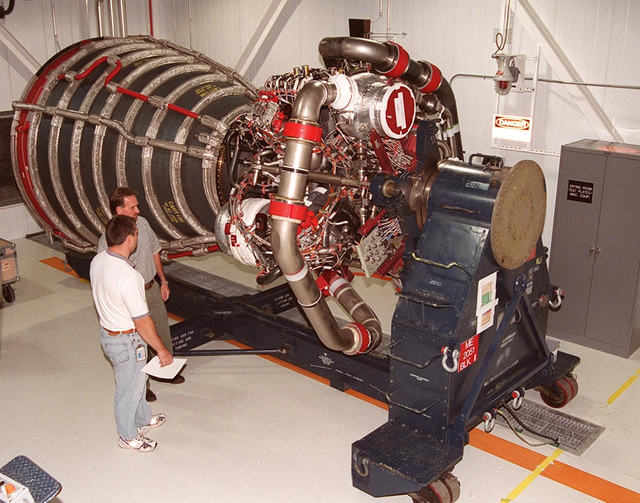 KENNEDY SPACE CENTER, FLA. -- Mike Cosgrove (front) and Bob Petrie (behind), both with Boeing/Rocketdyne, look over the upgraded Space Shuttle main engine (block 2 engine) as it sits in the Space Shuttle Main Engine Processing Facility. The new engine will be installed for its first flight on the orbiter Atlantis, on mission STS-104. The Block II Main Engine configuration is manufactured by Boeing Rocketdyne in Canoga Park, Calif., and includes a new Pratt & Whitney high-pressure fuel turbo pump. Engine improvements are managed by NASA’s Marshall Space Flight Center in Huntsville, Ala. Each Space Shuttle Main Engine is 14 feet (4.3 meters) long, weighs about 7,000 pounds (3,175 kilograms), and is 7.5 feet (2.3 meters) in diameter at the end of the nozzle