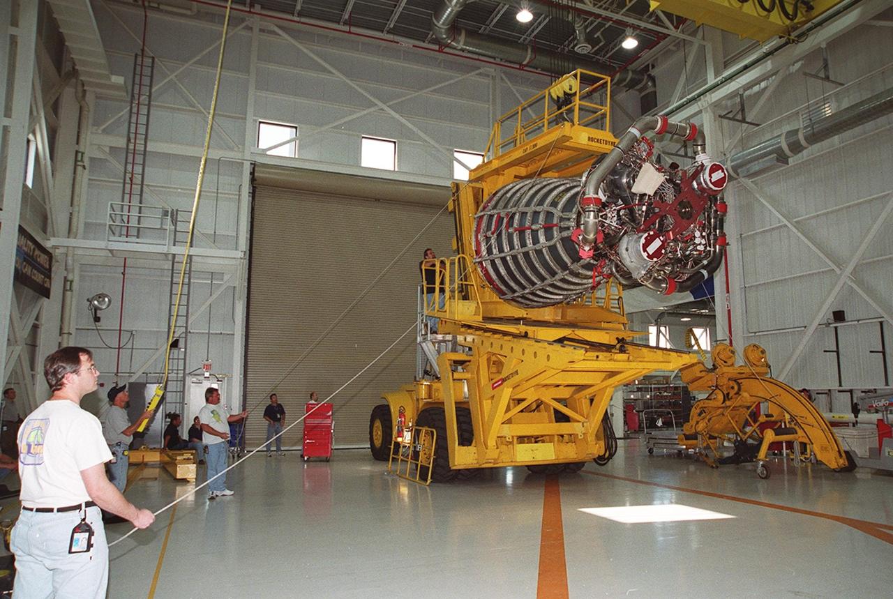 A new block 2 engine is lowered onto a transport vehicle for a move to the Orbiter Processing Facility. There it will be installed for its first flight on the orbiter Atlantis, on mission STS-104. The Block II Main Engine configuration is manufactured by Boeing Rocketdyne in Canoga Park, Calif., and includes a new Pratt & Whitney high-pressure fuel turbo pump. Engine improvements are managed by NASA’s Marshall Space Flight Center in Huntsville, Ala. Each Space Shuttle Main Engine is 14 feet (4.3 meters) long, weighs about 7,000 pounds (3,175 kilograms), and is 7.5 feet (2.3 meters) in diameter at the end of the nozzle