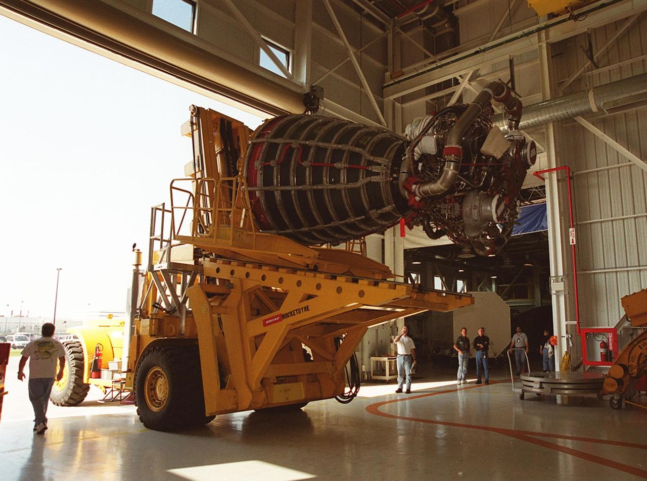 KENNEDY SPACE CENTER, FLA. -- The transport vehicle carrying a new block 2 engine leaves the Space Station Main Engine Processing Facility for a short trip to Orbiter Processing Facility bay 3. The new engine will be installed on the orbiter Atlantis, on mission STS-104, for its first flight. The Block II Main Engine configuration is manufactured by Boeing Rocketdyne in Canoga Park, Calif., and includes a new Pratt & Whitney high-pressure fuel turbo pump. Engine improvements are managed by NASA’s Marshall Space Flight Center in Huntsville, Ala. Each Space Shuttle Main Engine is 14 feet (4.3 meters) long, weighs about 7,000 pounds (3,175 kilograms), and is 7.5 feet (2.3 meters) in diameter at the end of the nozzle