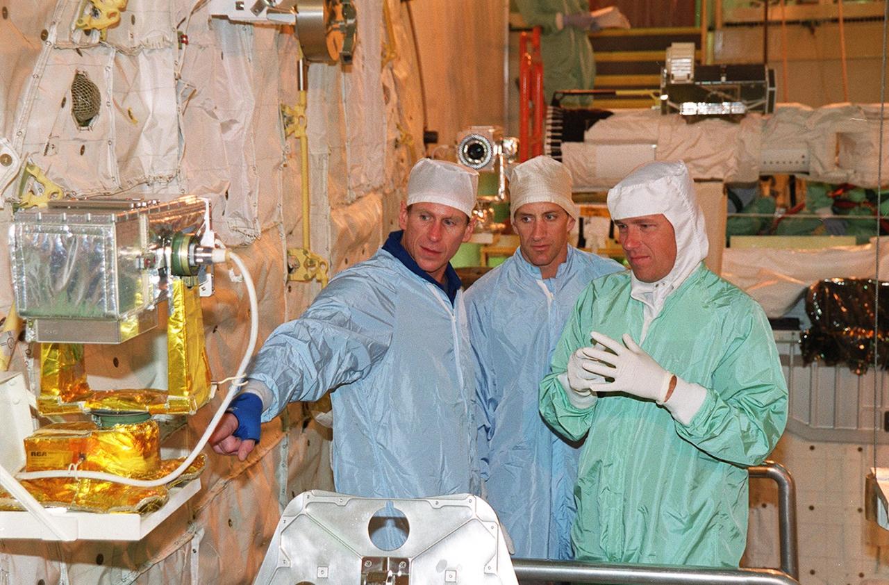 KENNEDY SPACE CENTER, FLA. -- In the Orbiter Processing Facility, STS-104 Mission Specialist Michael Gernhardt (left) and Pilot Charles Hobaugh (center) check out equipment in the payload bay of Atlantis. The STS-104 crew is at KSC to continue Crew Equipment Interface Test activities such as payload familiarization. The Joint Airlock Module is the primary payload on their mission, scheduled to launch no earlier than June 14, 2001, from Launch Pad 39B