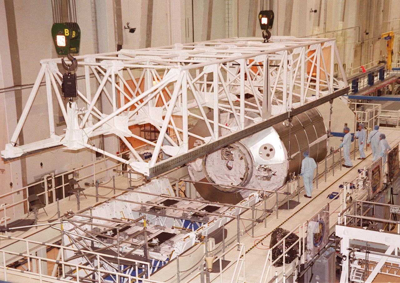 KENNEDY SPACE CENTER, FLA. -- An overhead crane in the Operations and Checkout Building places Multi-Purpose Logistics Module Donatello in a workstand. Donatello is one of three MPLMs built by the Italian Space Agency for ferrying supplies and equipment to the International Space Station. Donatello was transferred from the Space Station Processing Facility to the O&C