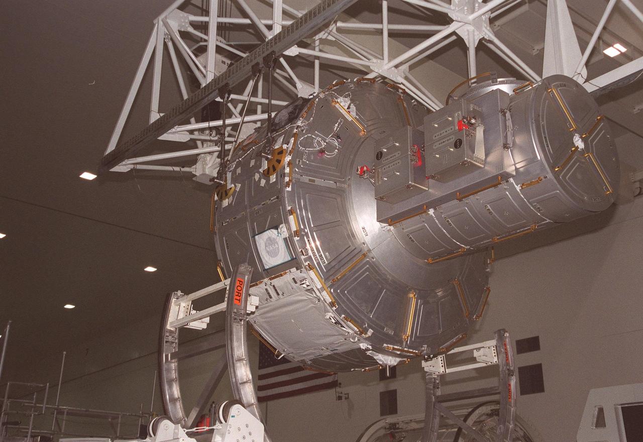KENNEDY SPACE CENTER, FLA. -- An overhead crane in the Space Station Processing Facility lifts the Joint Airlock Module from its workstand to move it to the Launch Package Integration Stand. The LPIS provides personnel and equipment access to the flight element in its final launch configuration. The Airlock is the primary payload on mission STS-104 to the International Space Station. It is a pressurized flight element consisting of two cylindrical chambers attached end-to-end by a connecting bulkhead and hatch. Once installed and activated, the Airlock becomes the primary path for spacewalk entry to and departure from the Space Station for U.S. spacesuits, which are known as Extravehicular Mobility Units, or EMUs. In addition, the Joint Airlock is designed to support the Russian Orlan spacesuit for EVA activity. STS-104 is scheduled for launch June 14 from Launch Pad 39B