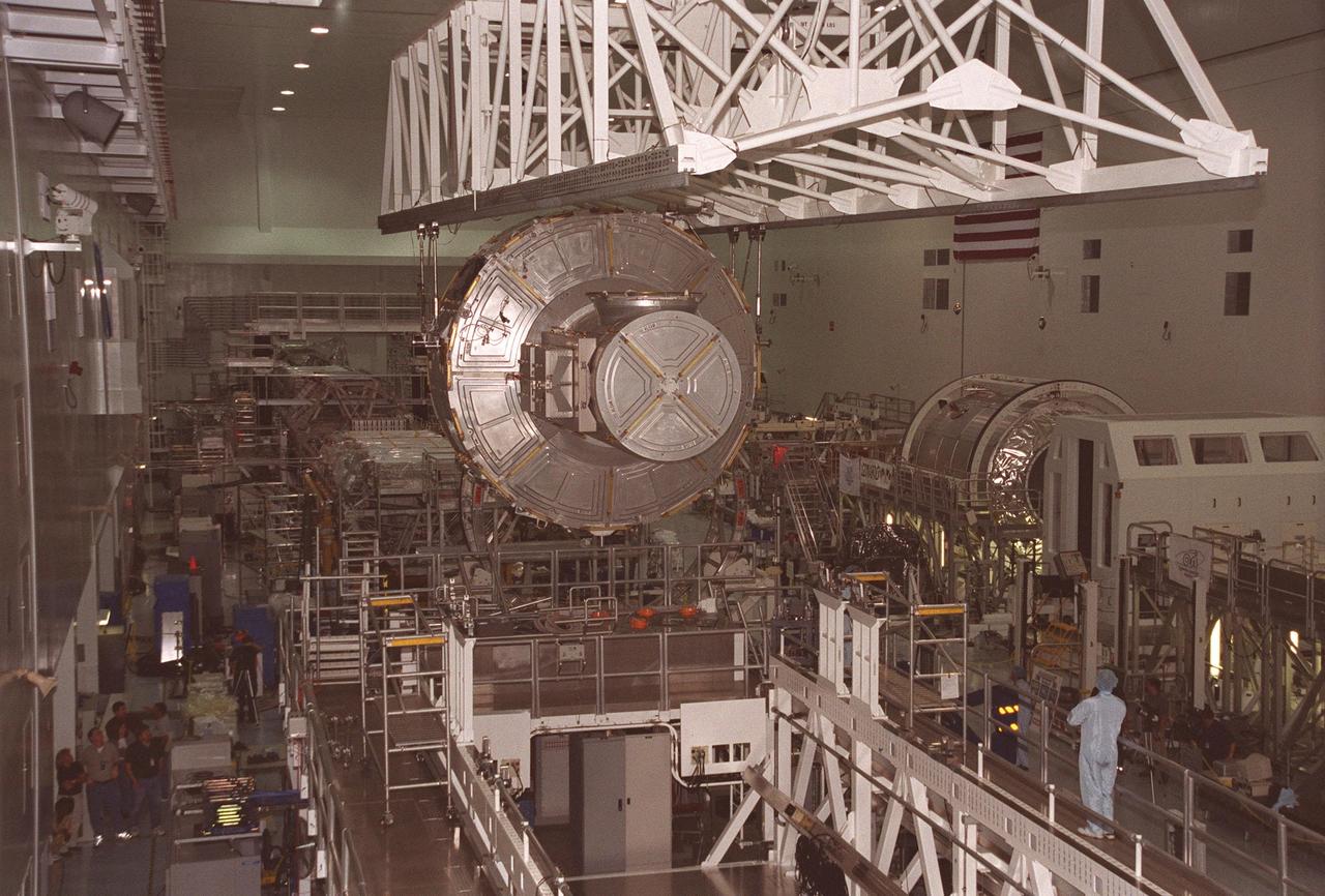 KENNEDY SPACE CENTER, FLA. -- In the Space Station Processing Facility, the Joint Airlock Module is moved from a workstand to the Launch Package Integration Stand. The LPIS provides personnel and equipment access to the flight element in its final launch configuration. The Airlock is the primary payload on mission STS-104 to the International Space Station. It is a pressurized flight element consisting of two cylindrical chambers attached end-to-end by a connecting bulkhead and hatch. Once installed and activated, the Airlock becomes the primary path for spacewalk entry to and departure from the Space Station for U.S. spacesuits, which are known as Extravehicular Mobility Units, or EMUs. In addition, the Joint Airlock is designed to support the Russian Orlan spacesuit for EVA activity. STS-104 is scheduled for launch June 14 from Launch Pad 39B