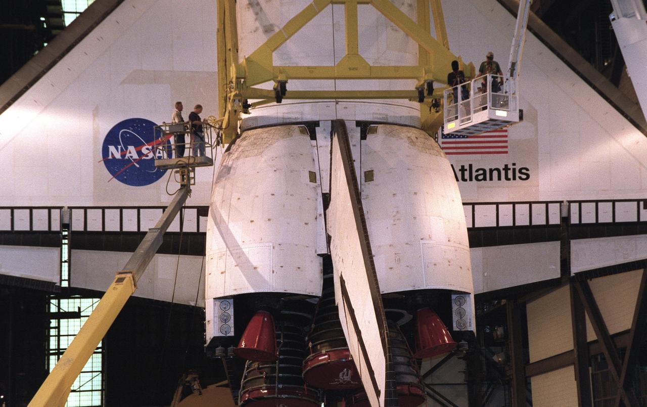 KENNEDY SPACE CENTER, FLA. -- This closeup shows the workers, standing on lifts, who are checking the bolts on the apparatus holding the orbiter Atlantis. The orbiter will be rotated and lifted into high bay 1 where it will be stacked with its external tank and solid rocket boosters. Space Shuttle Atlantis is scheduled to launch on mission STS-104 in early July