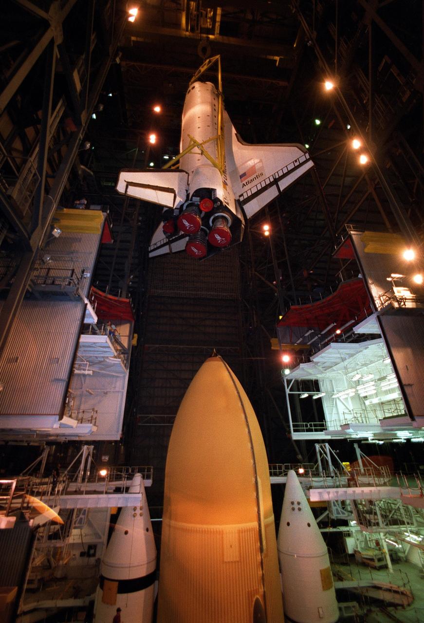 KENNEDY SPACE CENTER, FLA. -- In Vehicle Assembly Building high bay 1, the orbiter Atlantis is being lowered into position for mating to its external tank/solid rocket booster stack. Space Shuttle Atlantis is scheduled to launch on mission STS-104 in early July