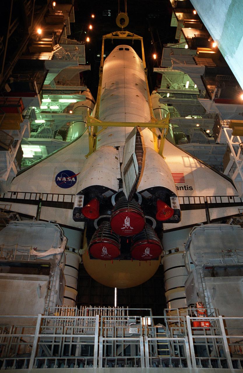 KENNEDY SPACE CENTER, FLA. -- In Vehicle Assembly Building high bay 1, the orbiter Atlantis is being lowered into position for mating to its external tank/solid rocket booster stack. Space Shuttle Atlantis is scheduled to launch on mission STS-104 in early July