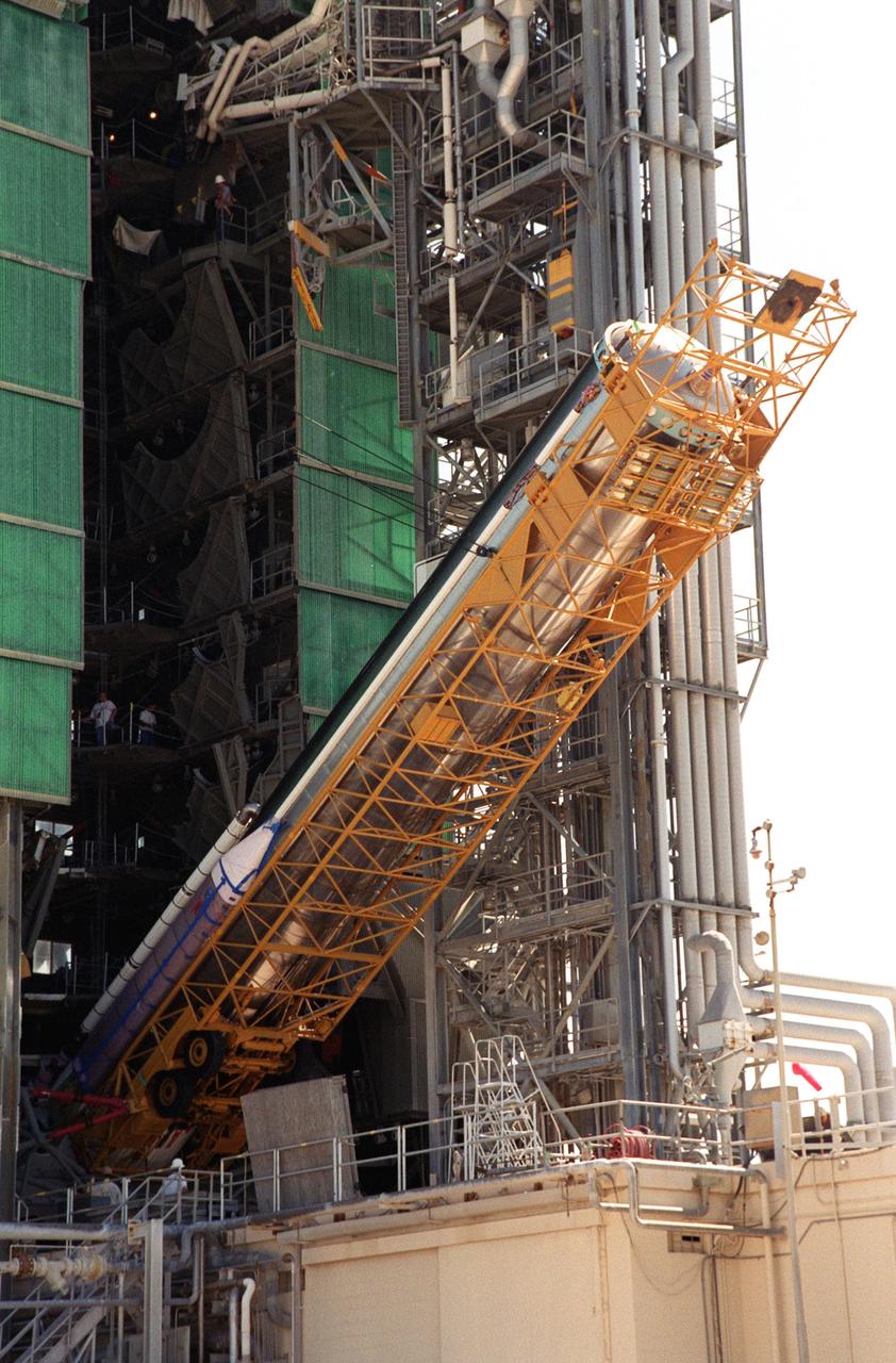 The first stage of the Geostationary Operational Environmental Satellite-M (GOES-M) Atlas II rocket is lifted to a vertical position at the gantry on Complex 36-A, Cape Canaveral Air Force Station. It will be raised and lifted up the gantry for mating with other stages. The last in the current series of advanced geostationary weather satellites in service, GOES-M has a new instrument not on earlier spacecraft, a Solar X-ray Imager that can be used in forecasting space weather, the effects of solar storms that create electromagnetic disturbances on earth that affect other satellites, communications and power grids. GOES-M is scheduled to launch from Cape Canaveral Air Force Station July 15