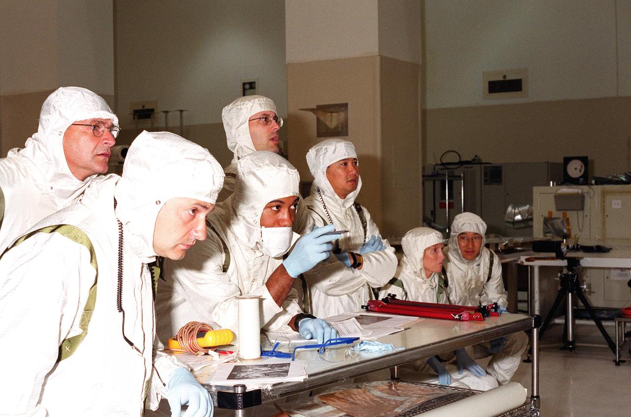 KENNEDY SPACE CENTER, FLA. -- Scientists and other workers watch as the solar panels on the Microwave Anisotropy Probe (MAP) spacecraft are deployed in the Spacecraft Assembly and Encapsulation Facility 2. MAP is scheduled for launch on June 30 aboard a Boeing Delta II rocket. The launch will place MAP into a lunar-assisted trajectory to the Sun-Earth for a 27-month mission. The probe will measure small fluctuations in the temperature of the cosmic microwave background radiation to an accuracy of one millionth of a degree. These measurements should reveal the size, matter content, age, geometry and fate of the universe. They will also reveal the primordial structure that grew to form galaxies and will test ideas about the origins of these primordial structures. The MAP instrument will be continuously shaded from the Sun, Earth, and Moon by the spacecraft. The probe is a product of Goddard Space Flight Center in partnership with Princeton University