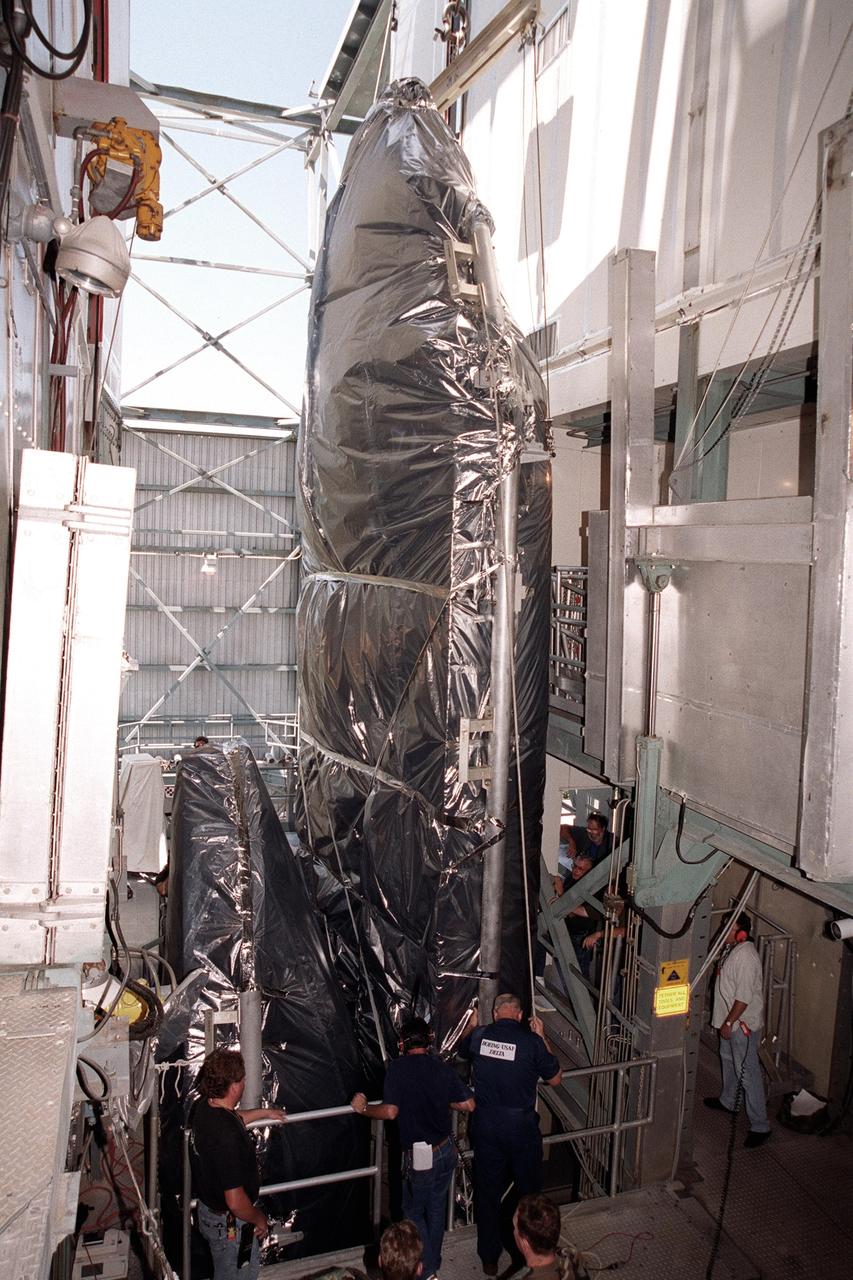 KENNEDY SPACE CENTER, FLA. -- At the gantry on Complex 17-A, Cape Canaveral Air Force Station, the fairing for the Microwave Anisotropy Probe (MAP) spacecraft arrives in the White Room. There it will wait for the arrival of the spacecraft. MAP is scheduled for launch on June 30 aboard a Boeing Delta II rocket. The launch will place MAP into a lunar-assisted trajectory to the Sun-Earth for a 27-month mission. The probe will measure small fluctuations in the temperature of the cosmic microwave background radiation to an accuracy of one millionth of a degree. These measurements should reveal the size, matter content, age, geometry and fate of the universe. They will also reveal the primordial structure that grew to form galaxies and will test ideas about the origins of these primordial structures. The MAP instrument will be continuously shaded from the Sun, Earth, and Moon by the spacecraft. The probe is a product of Goddard Space Flight Center in partnership with Princeton University