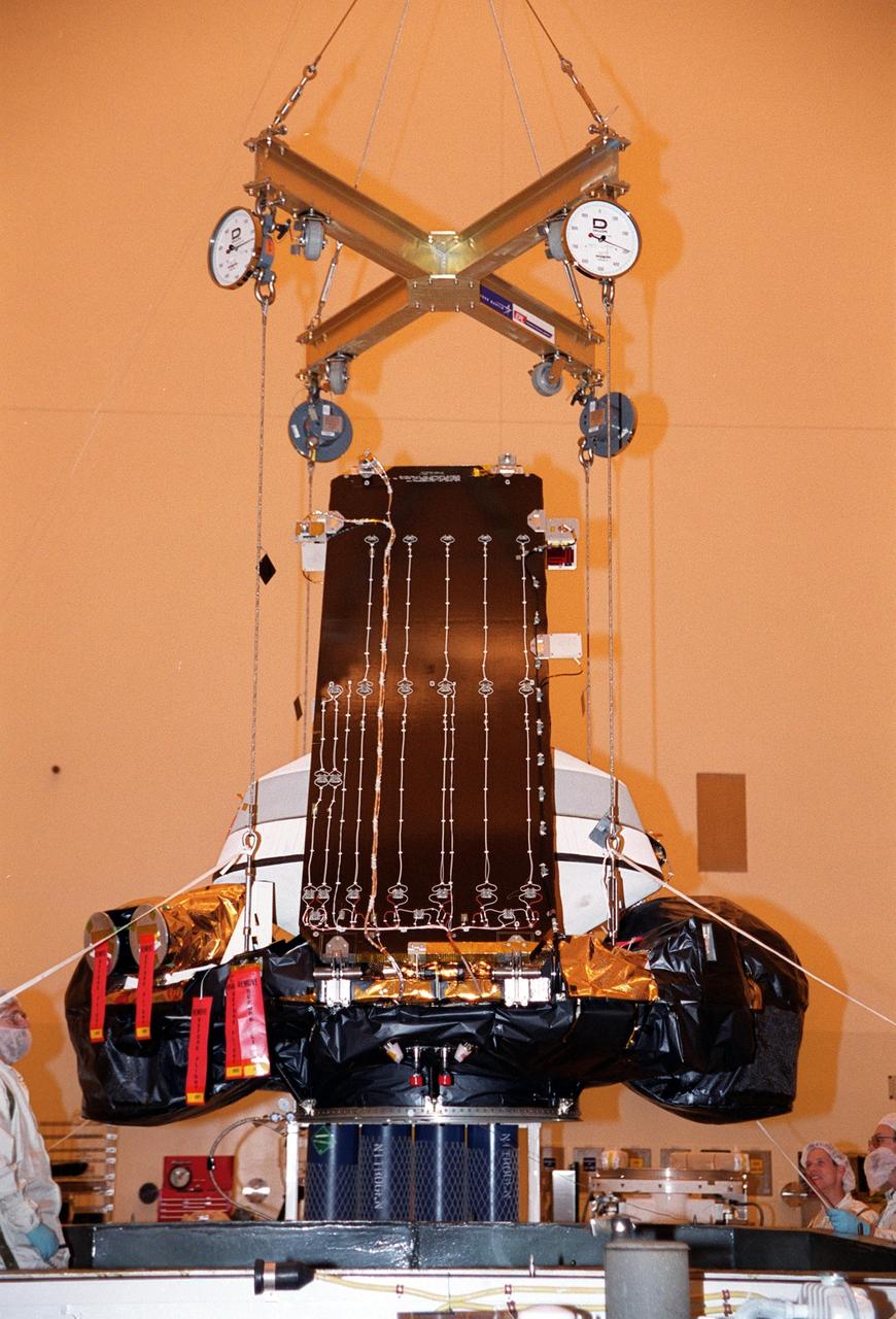 KENNEDY SPACE CENTER, Fla. -- In the Payload Hazardous Servicing Facility, the Genesis spacecraft is lifted out of its container before being moved to a workstand. Genesis is designed to collect samples of solar wind particles and return them to Earth so that scientists can study the exact composition of the Sun and probe the solar system’s origin. On the workstand, the spacecraft will undergo processing, which includes a functional test, electrical systems test and deployment of the solar arrays. Genesis is scheduled to be launched on a Delta II Lite launch vehicle from Complex 17-A, Cape Canaveral Air Force Station, July 30, at 12:36 p.m. EDT