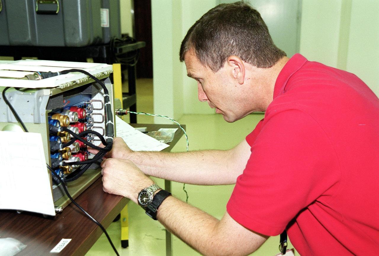KENNEDY SPACE CENTER, Fla. -- During Crew Equipment Interface Test (CEIT)activities at Spacehab, Cape Canaveral, Fla., STS-107 Commander Rick Douglas Husband checks out a piece of equipment. As a research mission, STS-107 will carry the Spacehab Double Module in its first research flight into space and a broad collection of experiments ranging from material science to life science. The CEIT activities enable the crew to perform certain flight operations, operate experiments in a flight-like environment, evaluate stowage locations and obtain additional exposure to specific experiment operations. Other STS-107 crew members are Pilot William C. McCool; Payload Commander Michael P. Anderson; Mission Specialists Kalpana Chawla, David M. Brown and Laurel Blair Salton Clark; and Payload Specialist Ilan Ramon, of Israel. STS-107 is scheduled for launch May 23, 2002