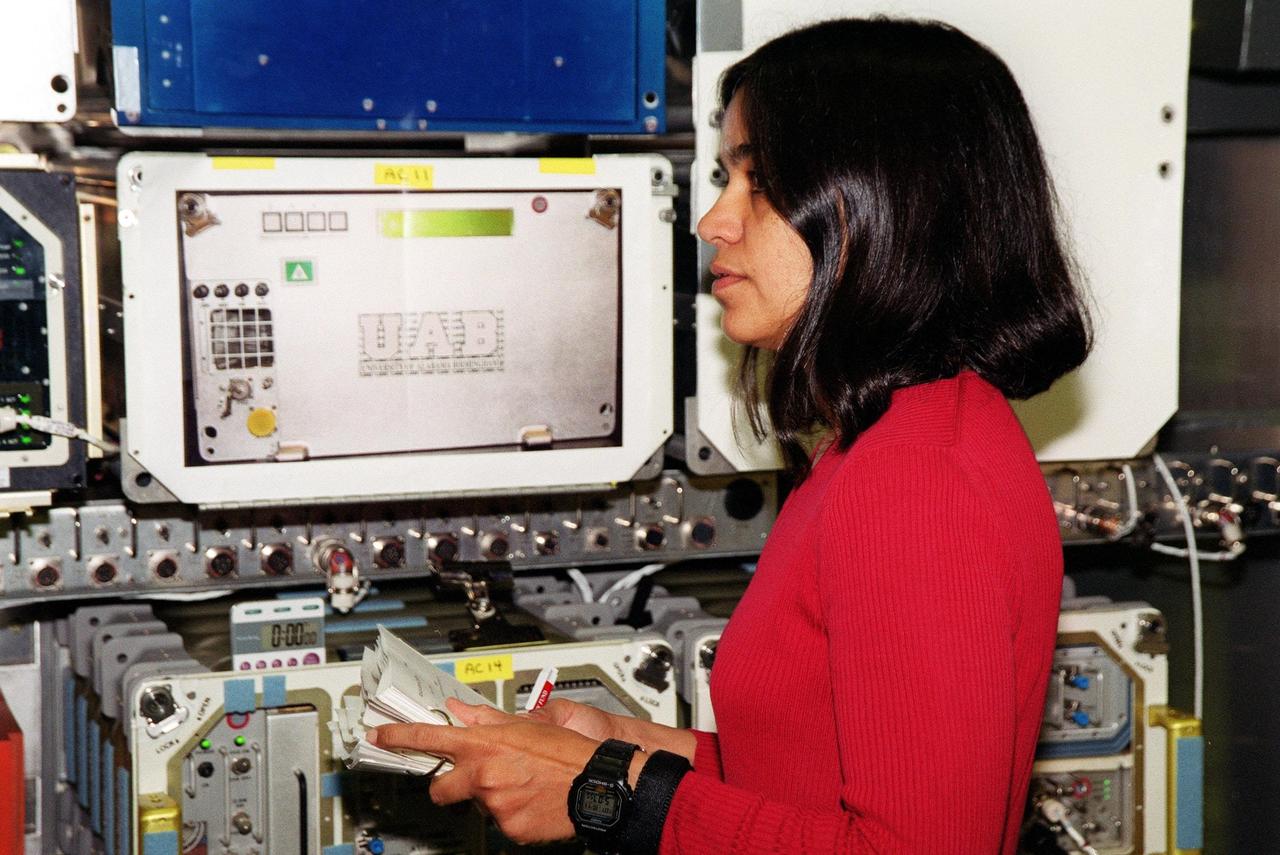 KENNEDY SPACE CENTER, Fla. -- During Crew Equipment Interface Test (CEIT)activities at SPACEHAB, Cape Canaveral, Fla., STS-107 Mission Specialist Kalpana Chawla looks over equipment inside the Spacehab module. As a research mission, STS-107 will carry the Spacehab Double Module in its first research flight into space and a broad collection of experiments ranging from material science to life science. The CEIT activities enable the crew to perform certain flight operations, operate experiments in a flight-like environment, evaluate stowage locations and obtain additional exposure to specific experiment operations. Other STS-107 crew members are Commander Rick Douglas Husband; Pilot William C. McCool; Payload Commander Michael P. Anderson; Mission Specialists Laurel Blair Salton Clark and David M. Brown; and Payload Specialist Ilan Ramon, of Israel. STS-107 is scheduled for launch May 23, 2002