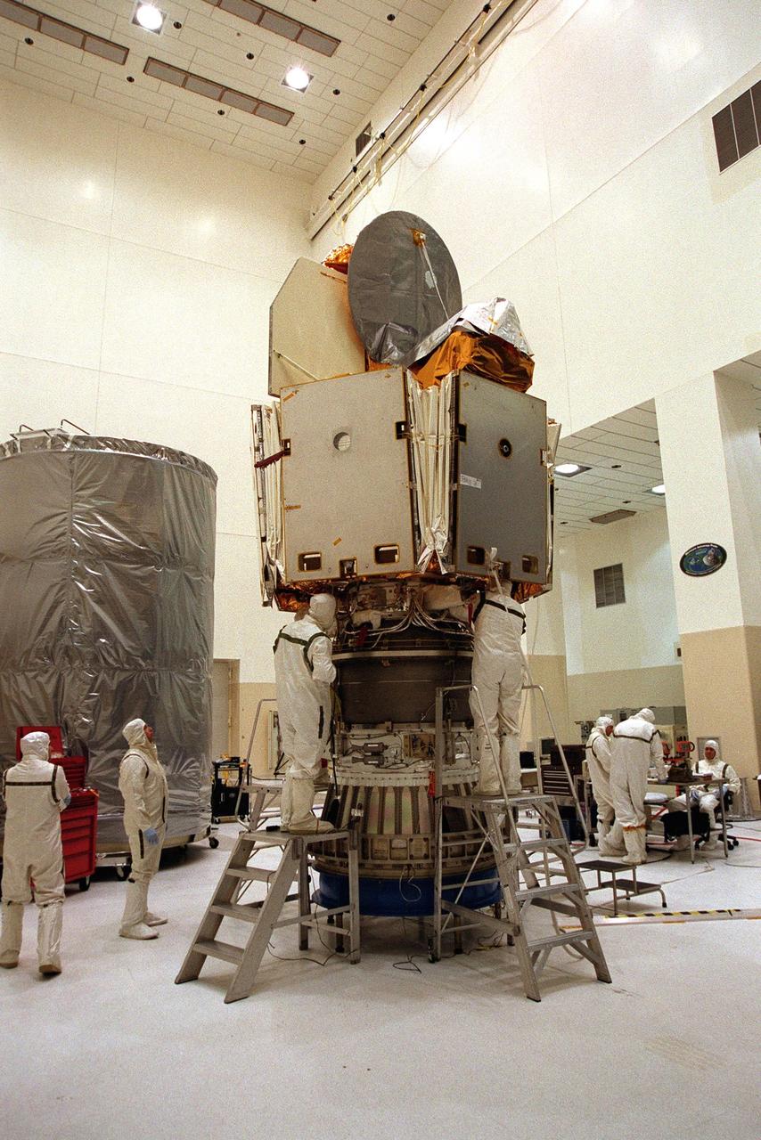 KENNEDY SPACE CENTER, Fla. -- Workers in the Spacecraft Assembly and Encapsulation Facility -2 prepare the Microwave Anisotropy Probe (MAP) for a media showing. The MAP is mated to the upper stage of the Boeing Delta II rocket. The rocket is scheduled to launch the MAP instrument June 30 into a lunar-assisted trajectory to the Sun-Earth for a 27-month mission. MAP will measure small fluctuations in the temperature of the cosmic microwave background radiation to an accuracy of one millionth of a degree. These measurements should reveal the size, matter content, age, geometry and fate of the universe. They will also reveal the primordial structure that grew to form galaxies and will test ideas about the origins of these primordial structures. The MAP instrument will be continuously shaded from the Sun, Earth, and Moon by the spacecraft. It is a product of Goddard Space Flight Center in partnership with Princeton University