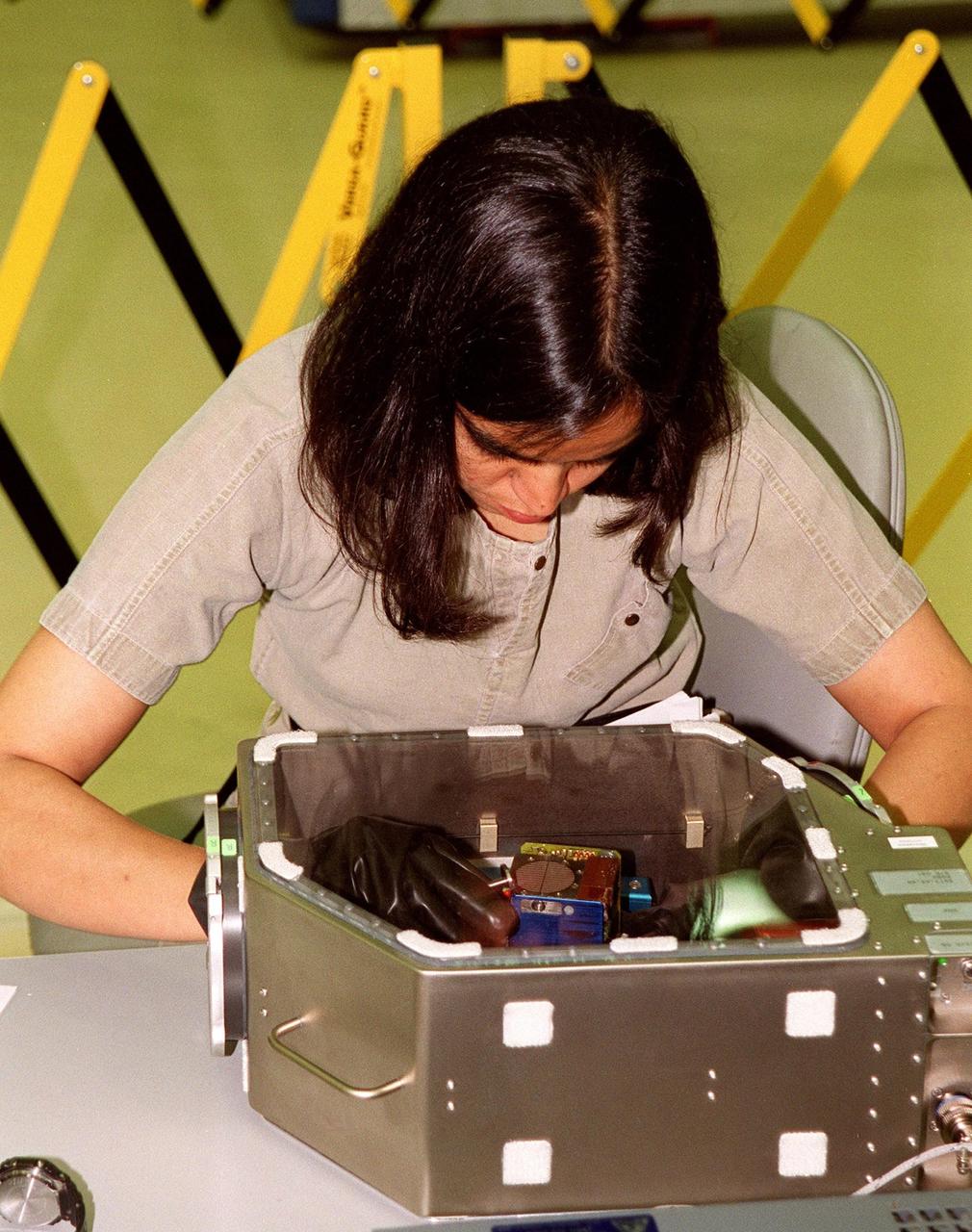 KENNEDY SPACE CENTER, Fla. -- During Crew Equipment Interface Test activities at SPACEHAB, Cape Canaveral, Fla., STS-107 Mission Specialist Kalpana Chawla trains on a glove box experiment. As a research mission, STS-107 will carry the SPACEHAB Double Module in its first research flight into space and a broad collection of experiments ranging from material science to life science. CEIT activities enable the crew to perform certain flight operations, operate experiments in a flight-like environment, evaluate stowage locations and obtain additional exposure to specific experiment operations. Other STS-107 crew members are Commander Rick Douglas Husband; Pilot William C. McCool; Payload Commander Michael P. Anderson; Mission Specialists Laurel Blair Salton Clark and David M. Brown; and Payload Specialist Ilan Ramon, of Israel. STS-107 is scheduled for launch May 23, 2002