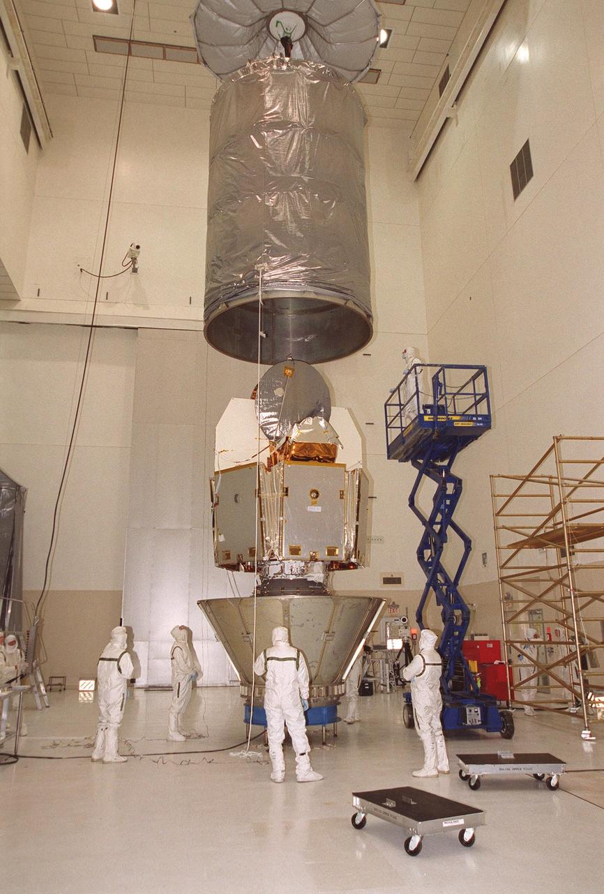 KENNEDY SPACE CENTER, Fla. -- In KSC’s Spacecraft Assembly and Encapsulation Facility -2, workers lower a canister over the Microwave Anisotropy Probe (MAP) before transporting to Launch Complex 17, Cape Canaveral Air Force Station. Launch of MAP via a Boeing Delta II rocket is scheduled for June 30.