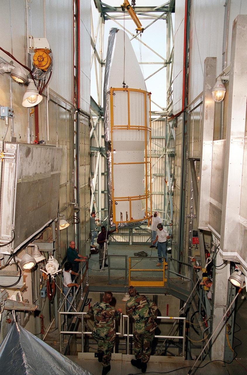 KENNEDY SPACE CENTER, Fla. -- At Launch Complex 17-A, Cape Canaveral Air Force Station, one part of the fairing for the Genesis spacecraft is being moved toward the opening in the foreground where the Genesis spacecraft waits for encapsulation. The fairing will protect the spacecraft during launch aboard a Delta II rocket. Genesis will be on a journey to capture samples of the ions and elements in the solar wind and return them to Earth for scientists to use to determine the exact composition of the Sun and the solar system’s origin. NASA’s Genesis project in managed by the Jet Propulsion Laboratory in Pasadena, Calif. Lockheed Martin Astronautics built the Genesis spacecraft for NASA in Denver, Colo. The launch is scheduled for July 30 at 12:36 p.m. EDT