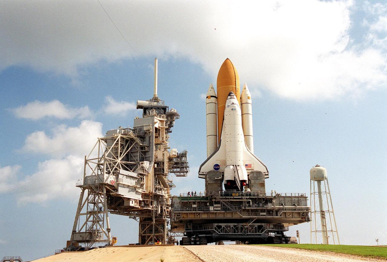 KENNEDY SPACE CENTER, Fla. -- Atop the mobile launcher platform, Space Shuttle Atlantis arrives on Launch Pad 39B after rollout from the Vehicle Assembly Building. Seen on either side of the orbiter’s tail are the tail service masts. They support the fluid, gas and electrical requirements of the orbiter’s liquid oxygen and liquid hydrogen aft umbilicals. The Shuttle is targeted for launch no earlier than July 12 on mission STS-104, the 10th flight to the International Space Station. The payload on the 11-day mission is the Joint Airlock Module, which will allow astronauts and cosmonauts in residence on the Station to perform future spacewalks without the presence of a Space Shuttle. The module, which comprises a crew lock and an equipment lock, will be connected to the starboard (right) side of Node 1 Unity. Atlantis will also carry oxygen and nitrogen storage tanks, vital to operation of the Joint Airlock, on a Spacelab Logistics Double Pallet in the payload bay. The tanks, to be installed on the perimeter of the Joint Module during the mission’s spacewalks, will support future spacewalk operations and experiments plus augment the resupply system for the Station’s Service Module