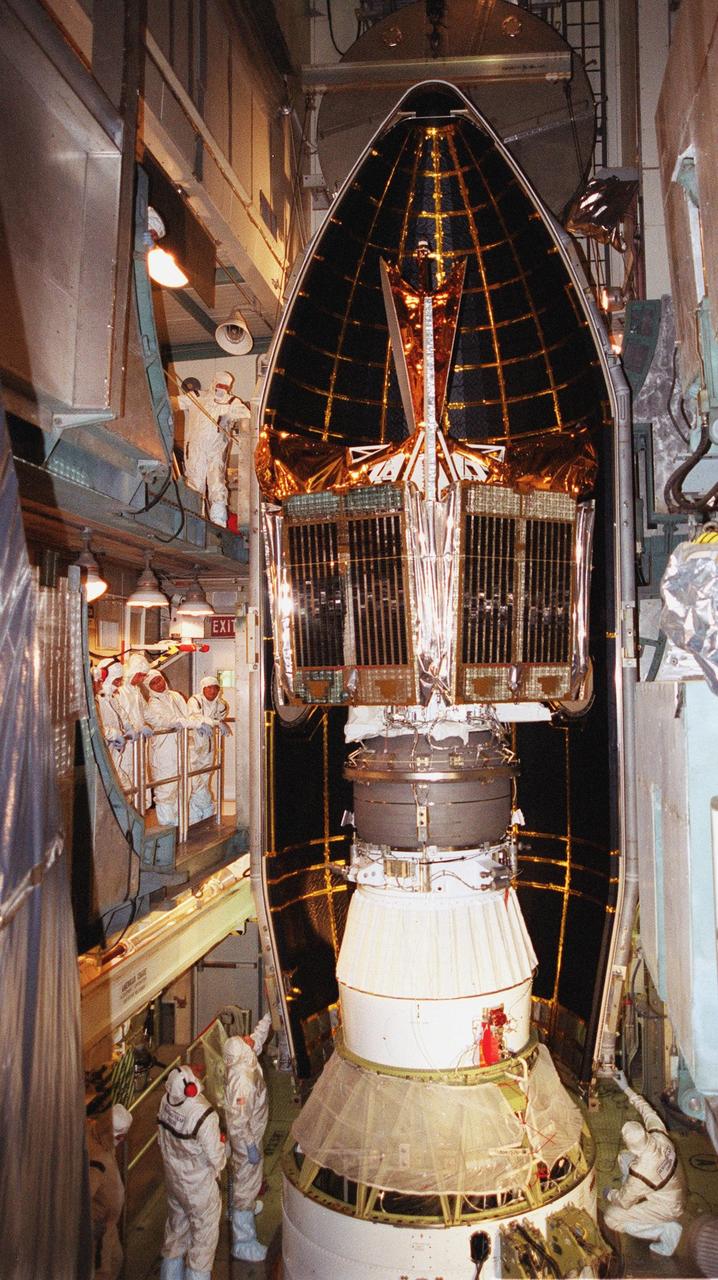 KENNEDY SPACE CENTER, Fla. -- Workers at Launch Complex 17-B, Cape Canaveral Air Force Station, watch as fairing moves into position around the Microwave Anisotropy Probe (MAP) spacecraft. MAP is scheduled for launch on June 30 aboard a Boeing Delta II rocket. The launch will place MAP into a lunar-assisted trajectory to the Sun-Earth for a 27-month mission. The probe will measure small fluctuations in the temperature of the cosmic microwave background radiation to an accuracy of one millionth of a degree. These measurements should reveal the size, matter content, age, geometry and fate of the universe. They will also reveal the primordial structure that grew to form galaxies and will test ideas about the origins of these primordial structures. The MAP instrument will be continuously shaded from the Sun, Earth, and Moon by the spacecraft