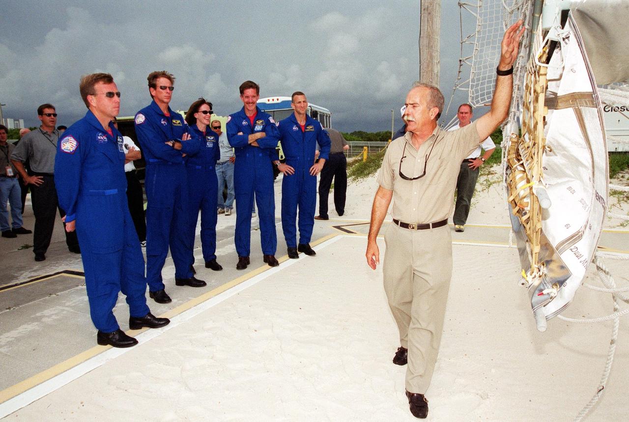 KENNEDY SPACE CENTER, Fla. -- During training at the launch pad, the STS-104 crew listen to instructions on use of the slidewire basket for emergency exit from the orbiter at the pad. Standing left to right are Commander Steven W. Lindsey, Mission Specialists Michael L. Gernhardt, Janet Lynn Kavandi and James F. Reilly, and Pilot Charles O. Hobaugh. The training is part of Terminal Countdown Demonstration Test activities, which also include opportunities to inspect their mission payloads in the orbiter’s payload bay and simulated countdown exercises. The launch of Atlantis on mission STS-104 is scheduled July 12 from Launch Pad 39B. The mission is the 10th flight to the International Space Station and carries the Joint Airlock Module