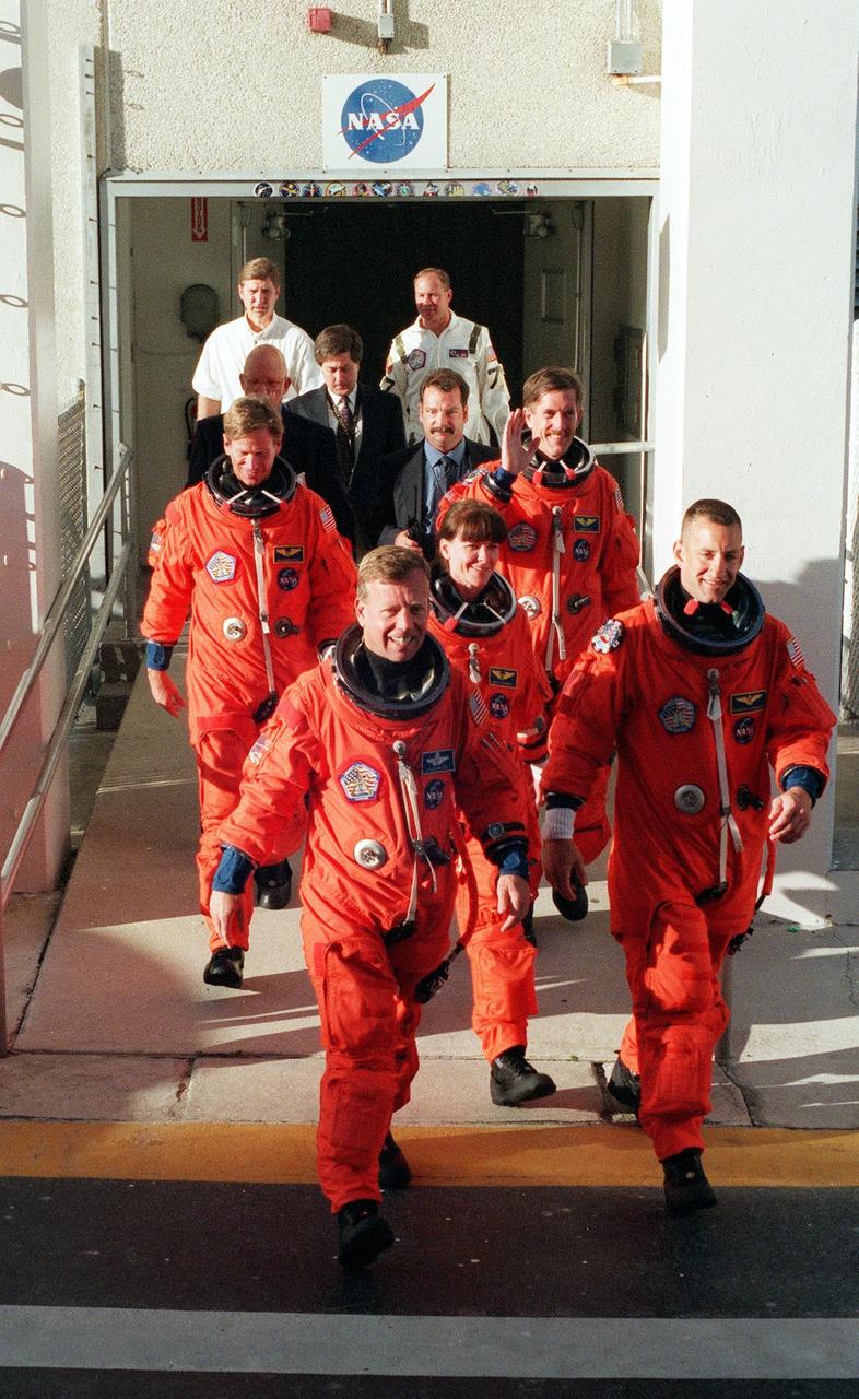 KENNEDY SPACE CENTER, Fla. -- The STS-104 crew walks out of the Operations and Checkout Building, on their way to Launch Pad 39B and a simulated countdown exercise. From back to front are Mission Specialists Michael L. Gernhardt (left) and James F. Reilly (right); middle, Mission Specialist Janet Lynn Kavandi; front, Commander Steven W. Lindsey (left) and Pilot Charles O. Hobaugh (right). The crew is taking part in Terminal Countdown Demonstration Test activities, which include emergency exit training from the orbiter, opportunities to inspect their mission payloads in the orbiter’s payload bay and simulated countdown exercises. The launch of Atlantis on mission STS-104 is scheduled July 12 from Launch Pad 39B. The mission is the 10th flight to the International Space Station and carries the Joint Airlock Module