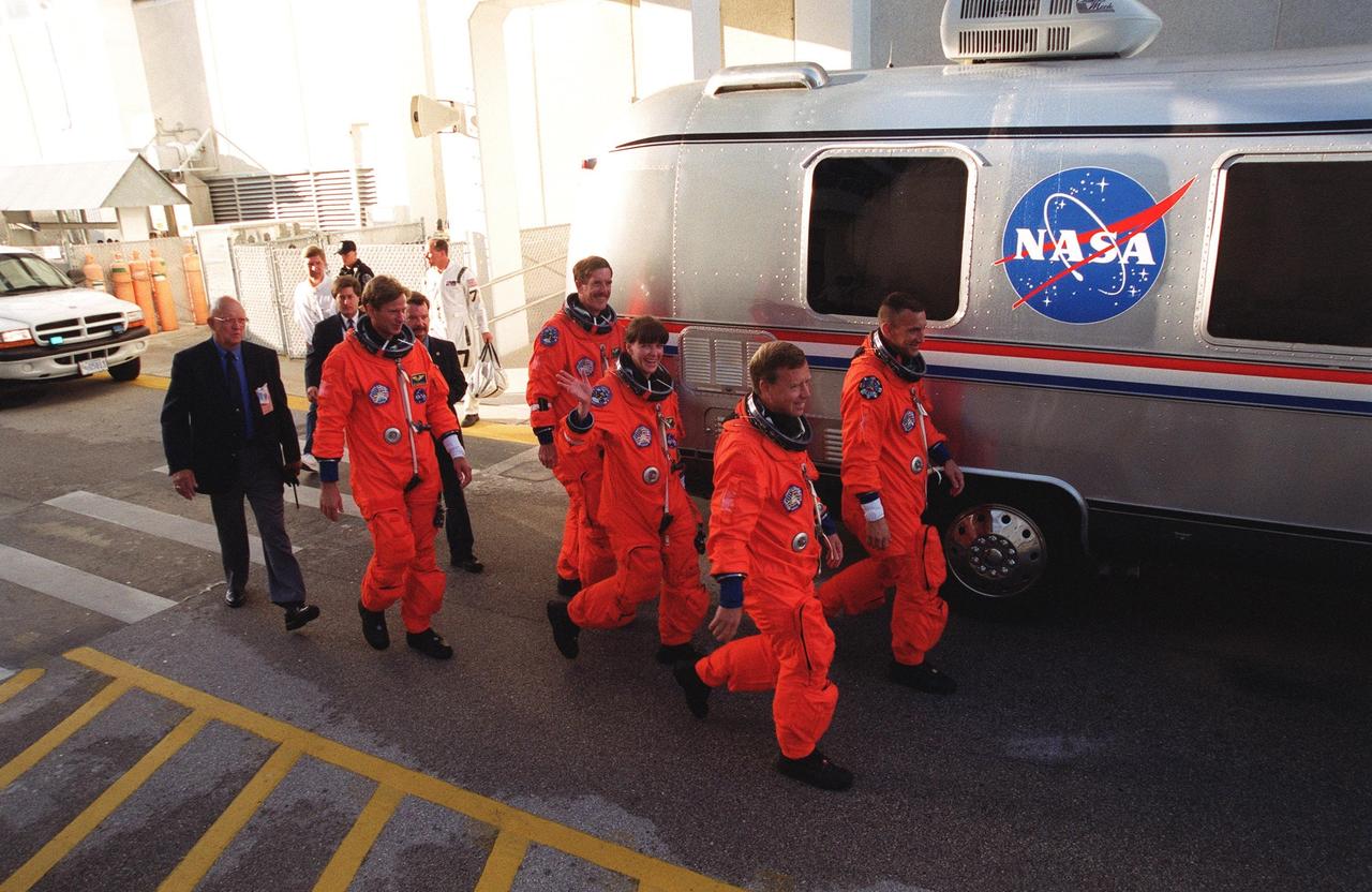 KENNEDY SPACE CENTER, Fla. -- Dressed in their orange launch and entry suits, the STS-104 crew eagerly walk to the Astrovan that will take them to Launch Pad 39B and a simulated countdown exercise. From left are Mission Specialists Michael L. Gernhardt, James F. Reilly and Janet Lynn Kavandi; Commander Steven W. Lindsey and Pilot Charles O. Hobaugh. The crew is taking part in Terminal Countdown Demonstration Test activities, which include emergency exit training from the orbiter, opportunities to inspect their mission payloads in the orbiter’s payload bay and simulated countdown exercises. The launch of Atlantis on mission STS-104 is scheduled July 12 from Launch Pad 39B. The mission is the 10th flight to the International Space Station and carries the Joint Airlock Module