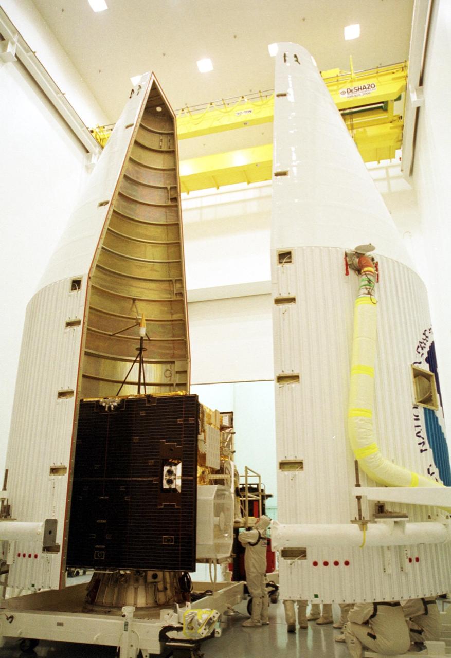 KENNEDY SPACE CENTER, Fla. -- At Astrotech, Titusville, Fla., both halves of the fairing are being installed around the newest Geostationary Operational Environmental Satellite-M (GOES-M). The satellite is the last in the current series of advanced geostationary weather satellites in service. GOES-M has a new instrument not on earlier spacecraft, a Solar X-ray Imager that can be used in forecasting space weather, the effects of solar storms that create electromagnetic disturbances on earth that affect other satellites, communications and power grids. GOES is scheduled to launch from Launch Complex 36-A, Cape Canaveral Air Force Station, on an Atlas II rocket July 15