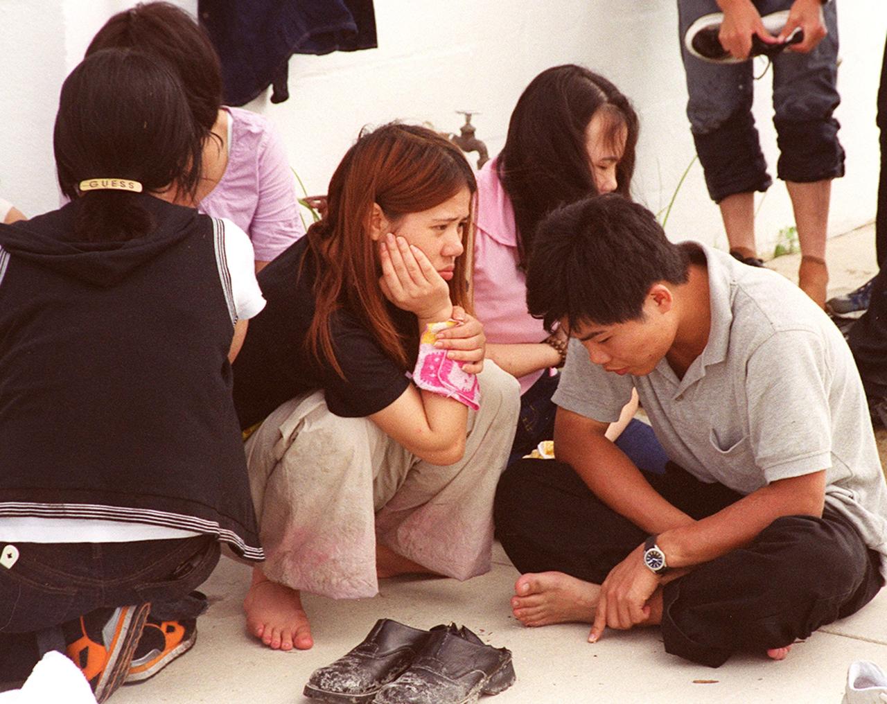 KENNEDY SPACE CENTER, Fla. -- These Chinese foreign nationals, part of a larger group who arrived unannounced on Kennedy Space Center grounds, wait for representatives of Immigration and Naturalization Services to transport them to an office in Orlando for processing
