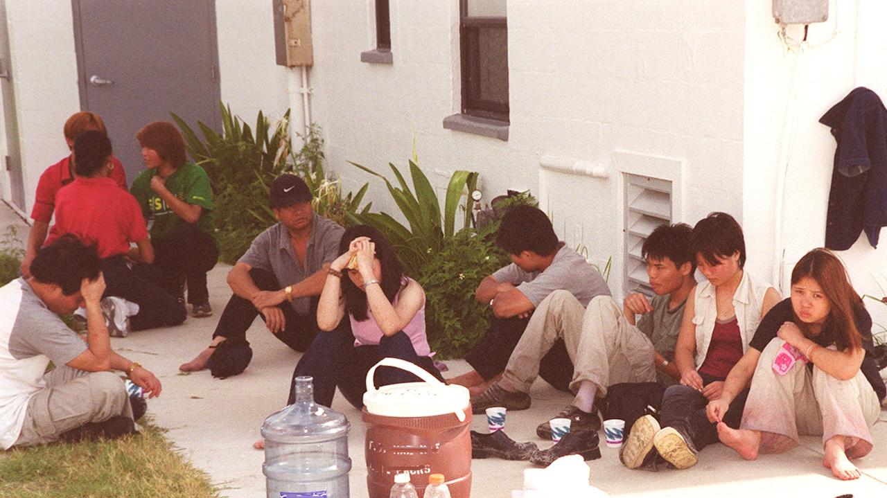 KENNEDY SPACE CENTER, Fla. -- This group of Chinese foreign nationals (foreground) are part of a larger group who arrived unannounced on Kennedy Space Center grounds. They are waiting for representatives of Immigration and Naturalization Services to transport them to an office in Orlando for processing