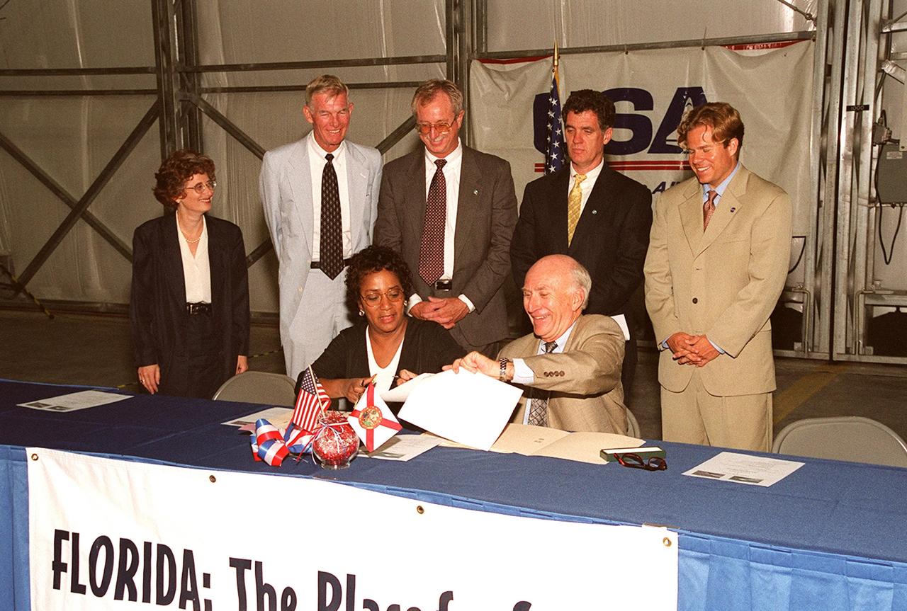 KENNEDY SPACE CENTER, Fla. -- The signing of a lease agreement between Spaceport Florida Authority (SFA) and United Space Alliance (USA) for the use of a hangar at Kennedy Space Center brings smiles to the participants. Seated at the table are (left) Marcie Harris, USA Site Director, and (right) Ed Gormel, Spaceport Florida Executive Director. Observing behind them are (left to right) Rochelle Cooper, USA associate general counsel; Marv Jones, KSC associate director; Greg Popp, Spaceport Florida business manager; Congressman Dave Weldon; and State Rep. Mike Haridopolos. The hangar was originally developed by the state as part of a joint NASA/SFA Reusable Launch Vehicle Support Complex at KSC. USA plans to use the state-developed 50,000-square-foot facility to store and maintain Space Shuttle ground equipment