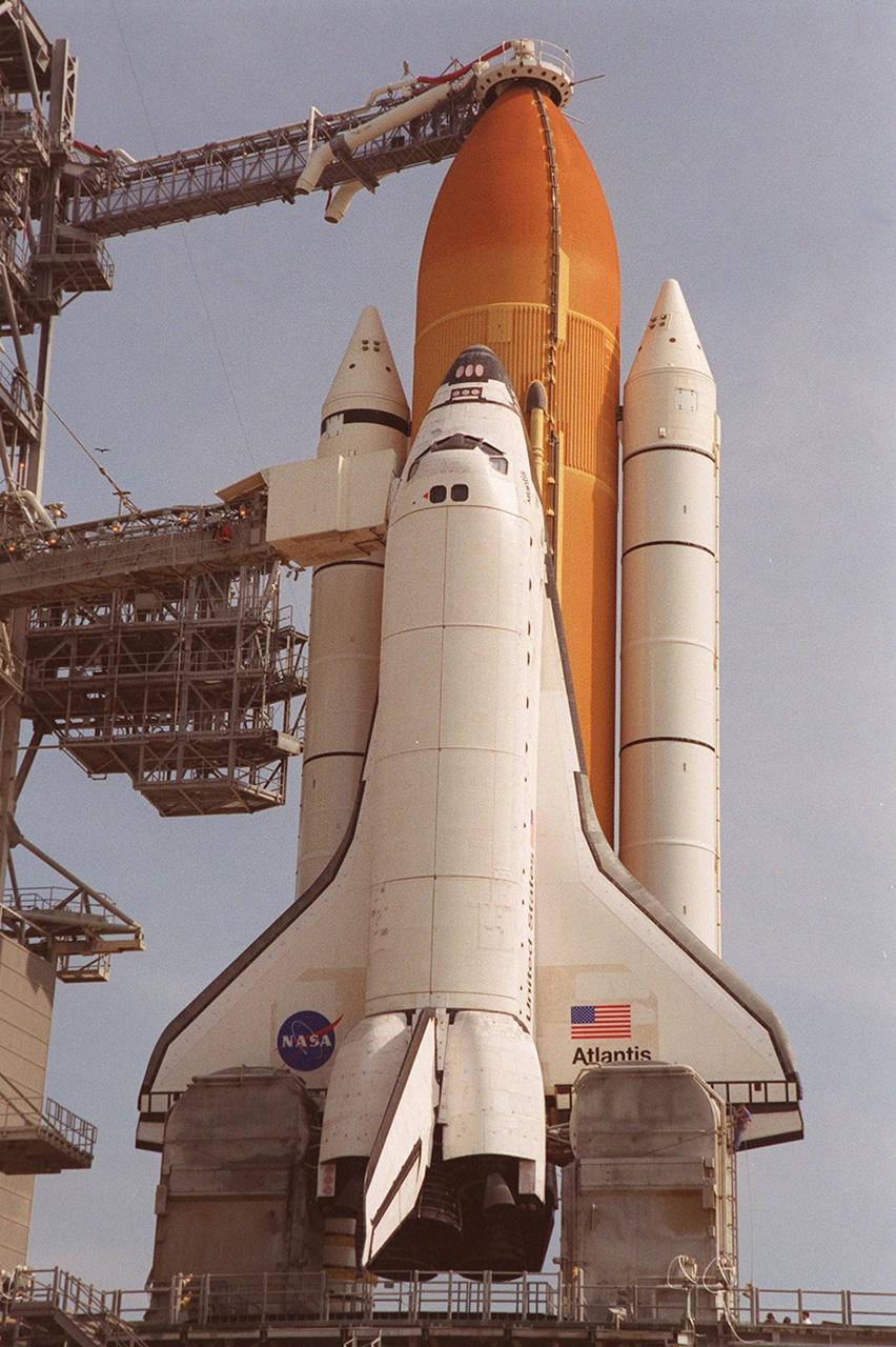 KENNEDY SPACE CENTER, Fla. -- After RSS rollback, Space Shuttle Atlantis is ready for final launch preparations. The orbiter access arm, with the environmentally controlled White Room at the end, is extended to the orbiter to allow entry into Atlantis. Above it is the gaseous oxygen vent arm with its characteristic “beanie cap” or hood placed over the external tank. The retractable arm and vent hood assembly allows gaseous oxygen vapors to vent away from the Space Shuttle vehicle. The vapors are created as the liquid oxygen in the external tank boils off. At the lower end of Atlantis are the tail service masts, in front of either wing. The masts support the fluid, gas and electrical requirements of the orbiter’s liquid oxygen and liquid hydrogen aft T-0 umbilicals. Launch on mission STS-104 is scheduled for 5:04 a.m. July 12. The launch is the 10th assembly flight to the International Space Station. Along with a crew of five, Atlantis will carry the joint airlock module as primary payload